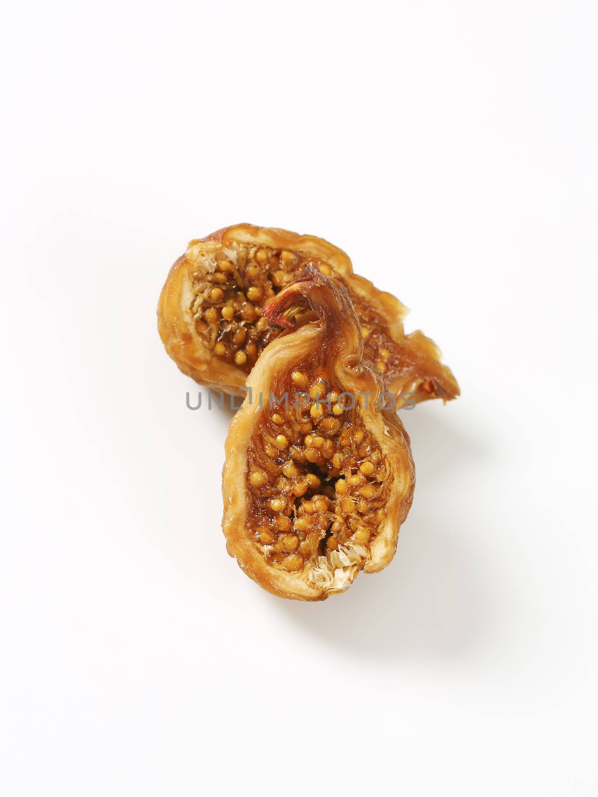 halved dried fig on white background