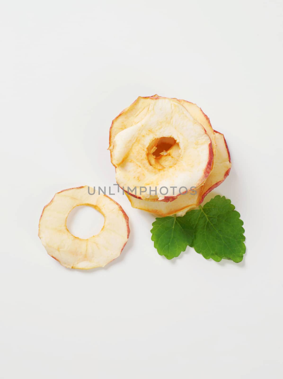 stack of dried apple chips on white background