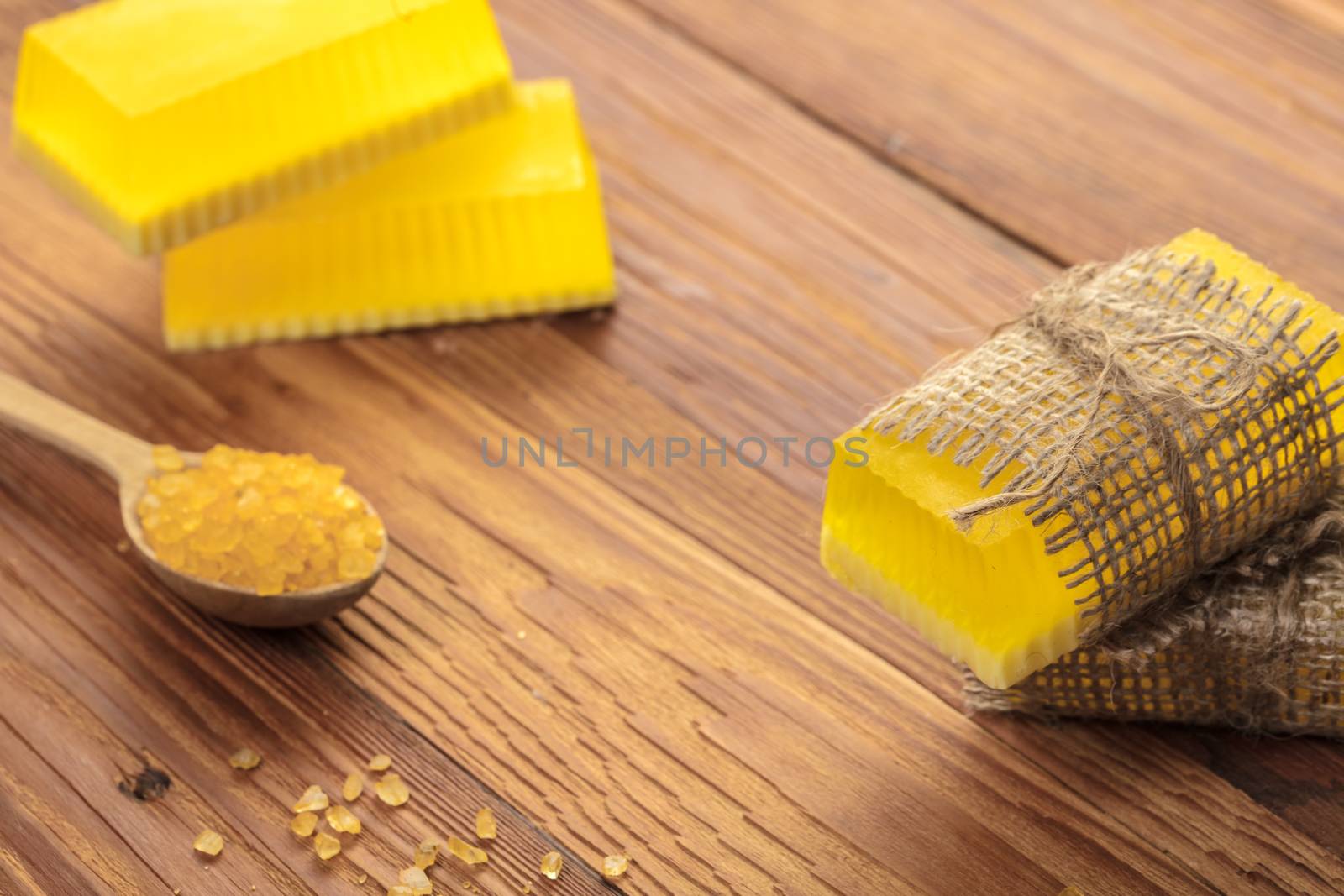 Yellow handmade soap and phyto salt on a wooden background
