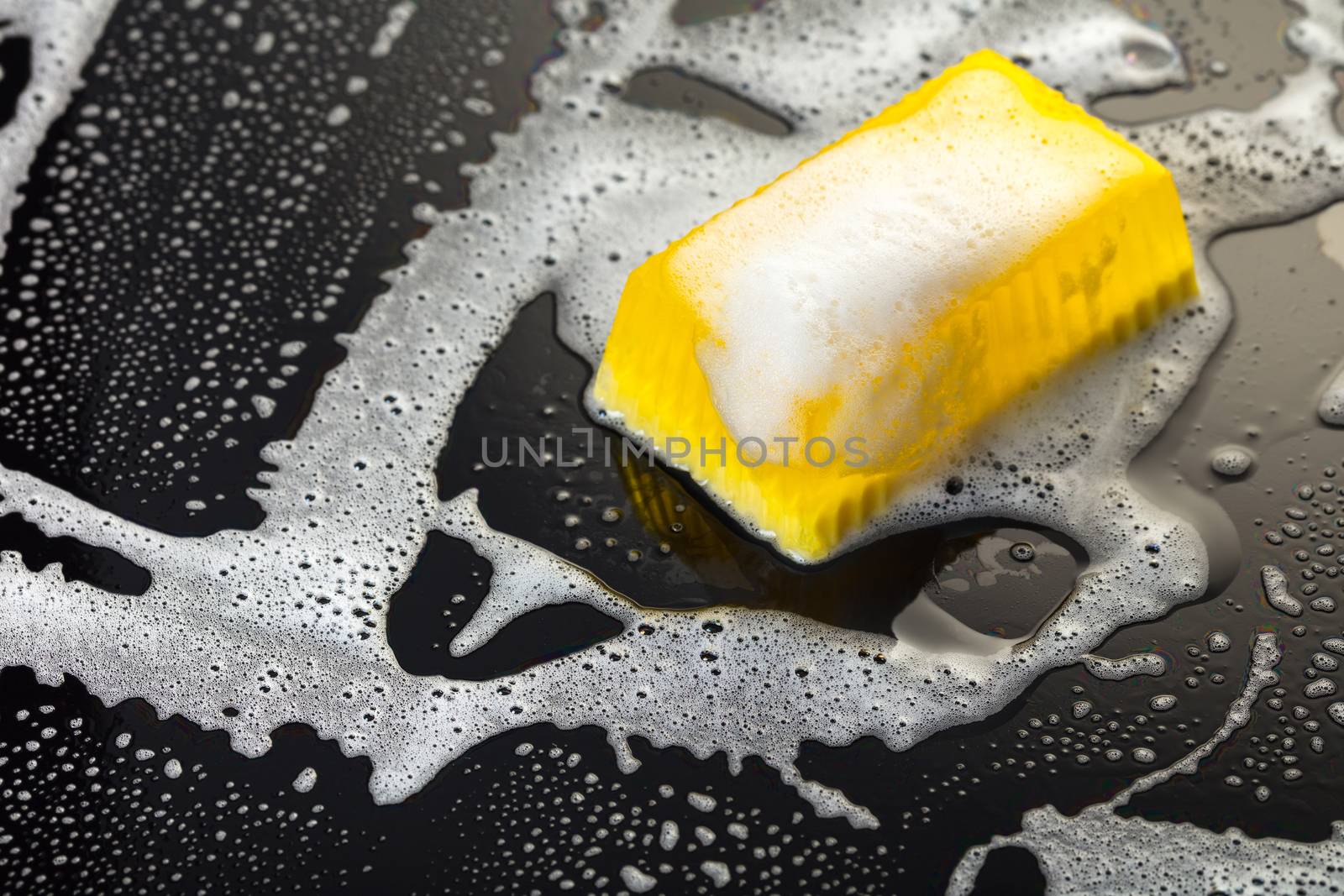 Handmade soap yellow on a black background with foam