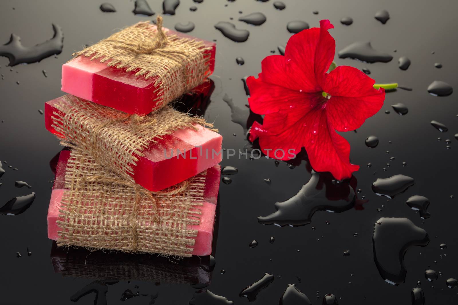 Handmade soap red with a flower petunia on black background