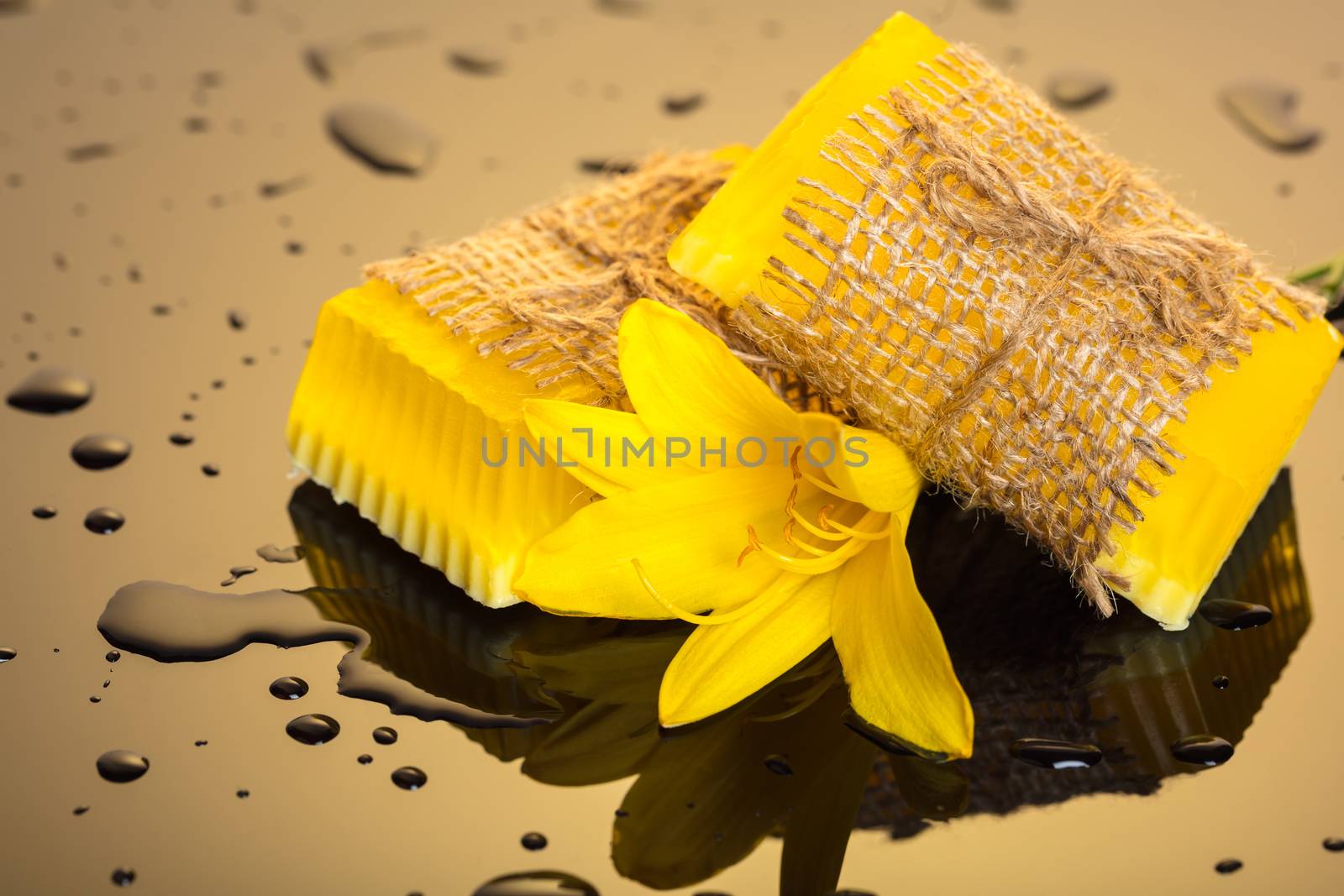 Handmade soap yellow on a dark background with drops of water