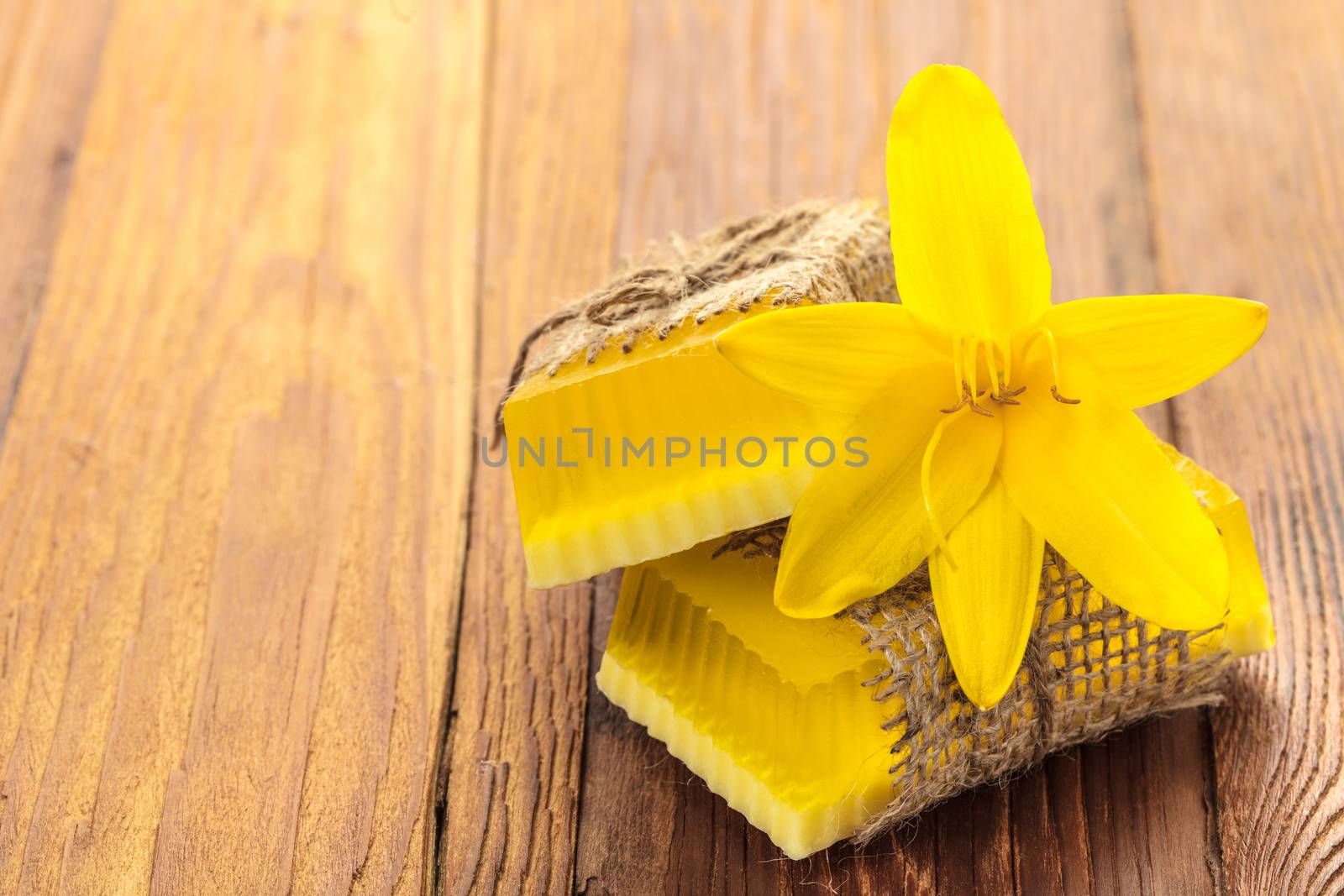 Yellow floral handmade soap on a wooden background