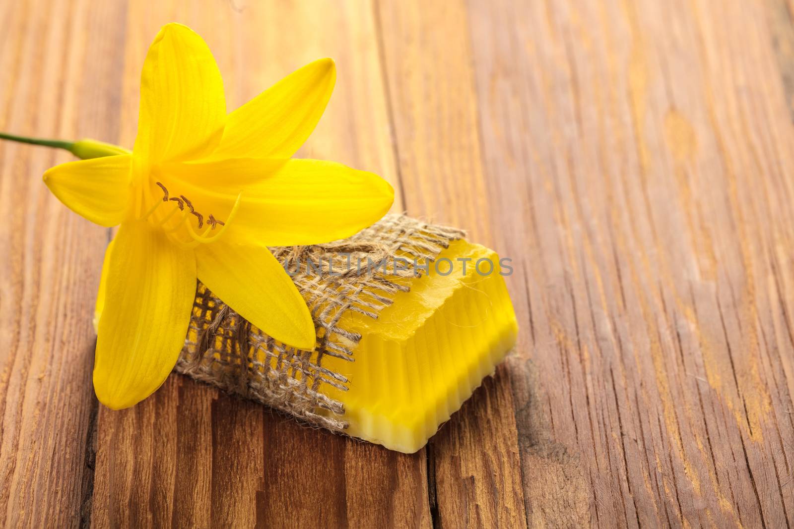 Yellow floral handmade soap on a wooden background