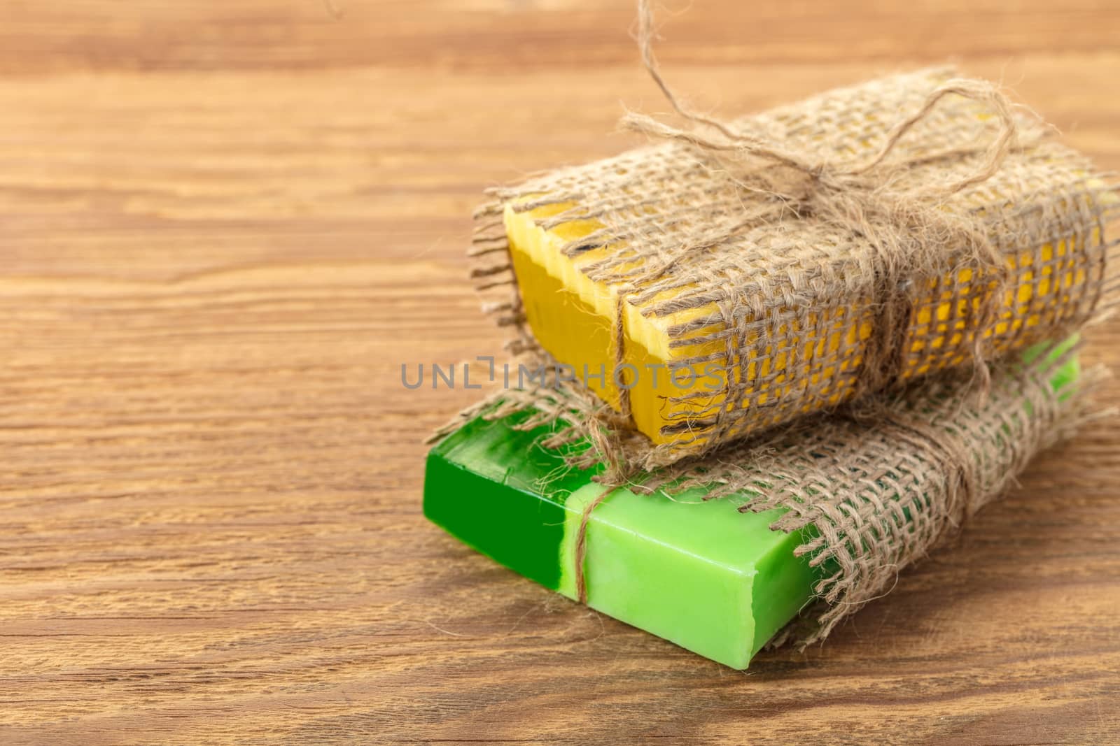 Yellow and green handmade soaps in a vintage packaging on wooden background