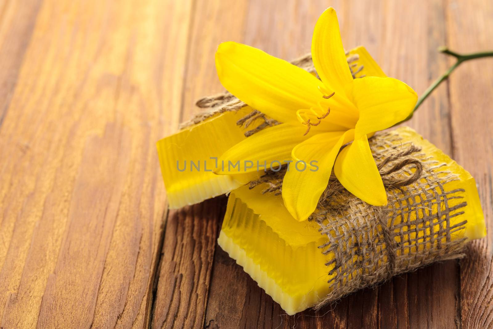 Yellow floral handmade soap on a wooden background