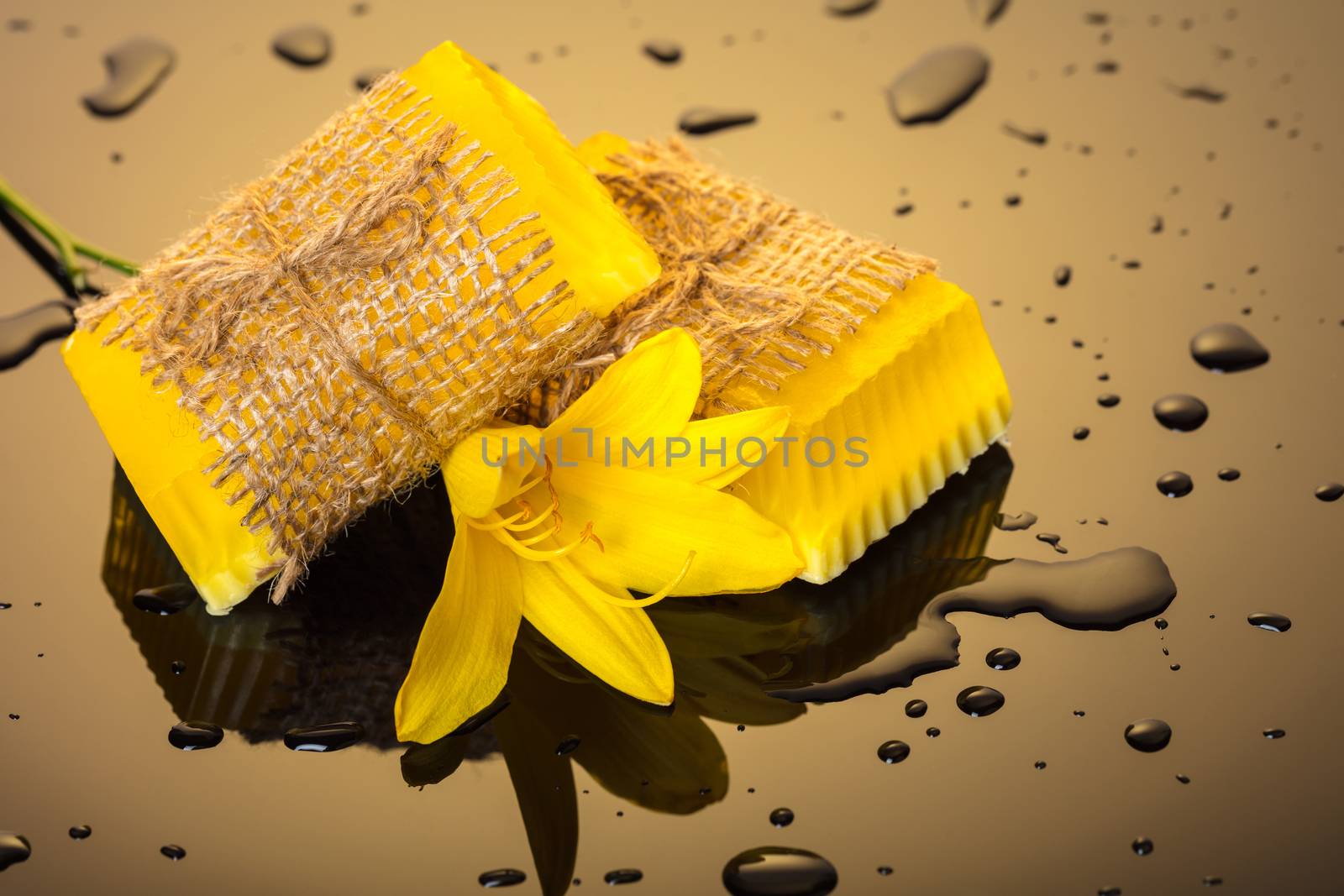 Handmade soap yellow on a dark background with drops of water