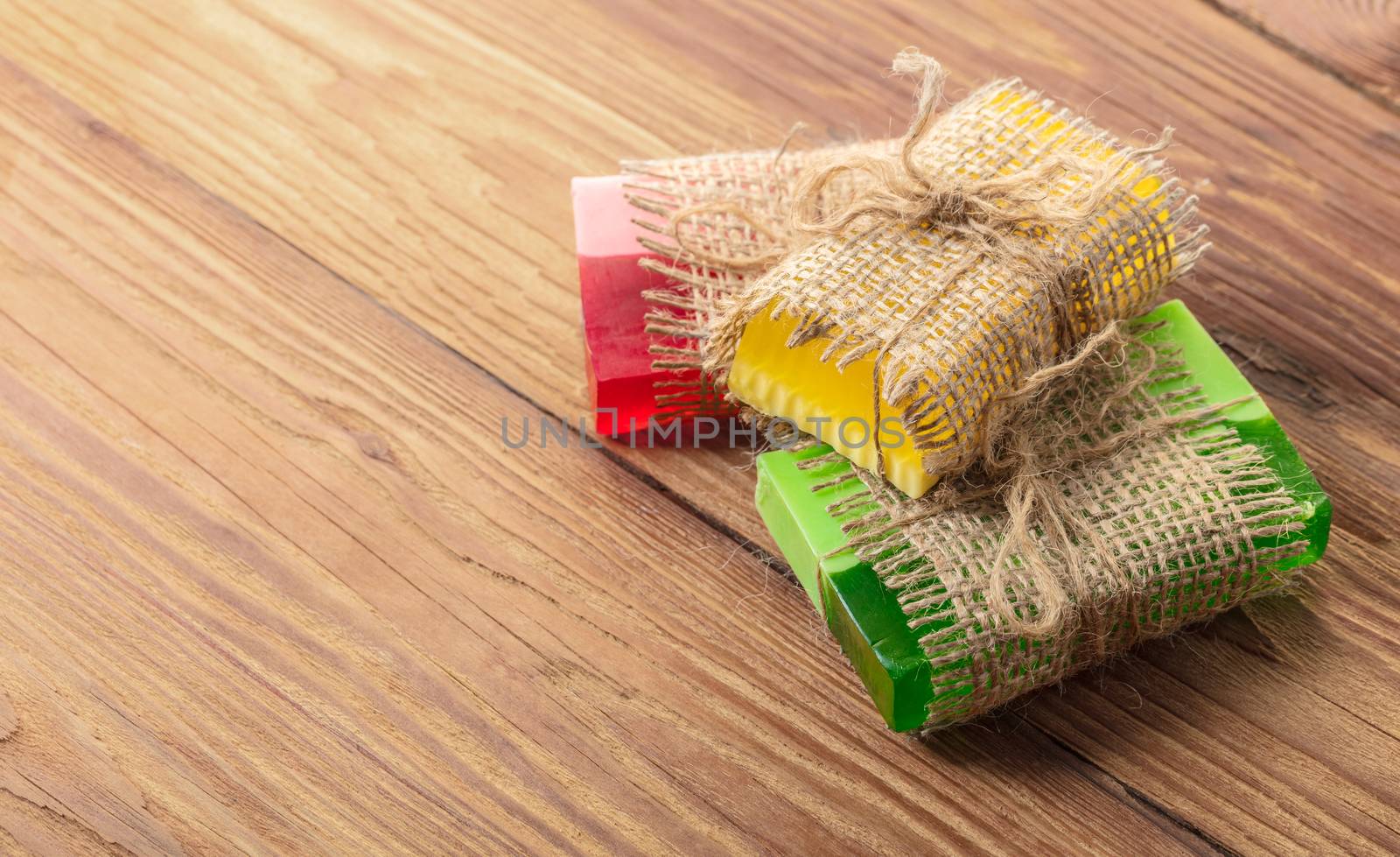 Colored handmade soap in a vintage packaging on wooden background