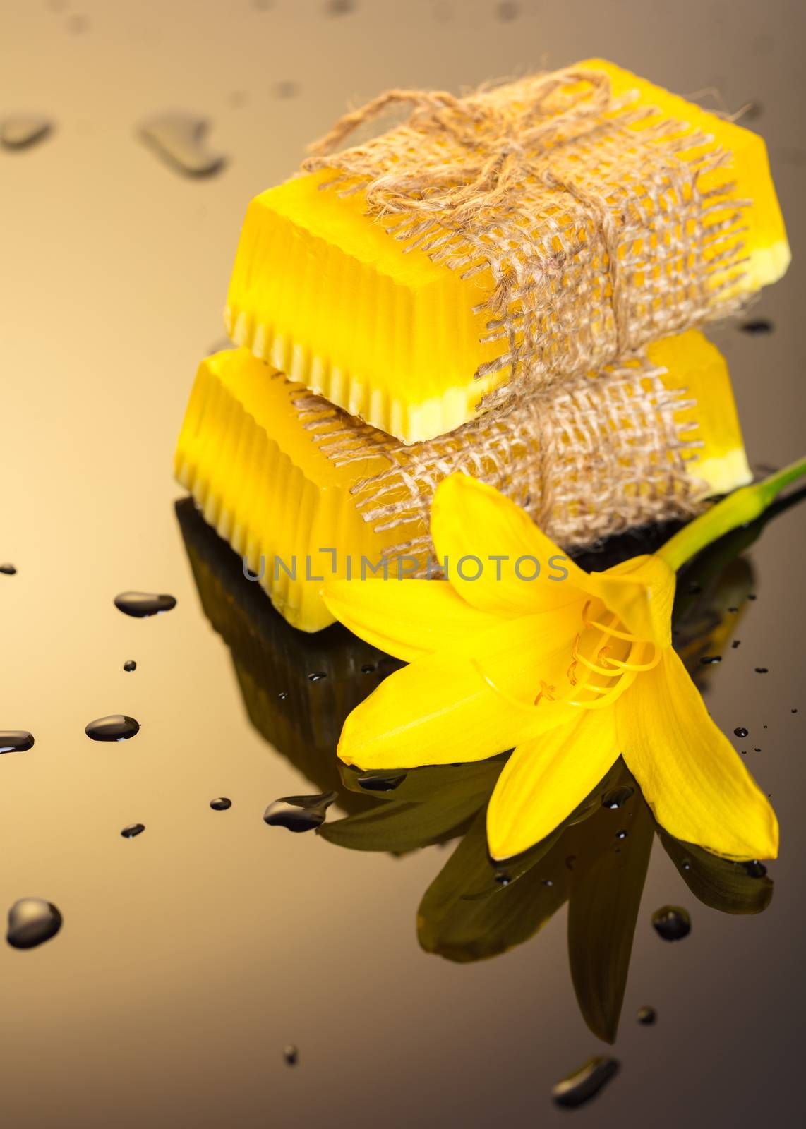 Handmade soap yellow on a dark background with drops of water