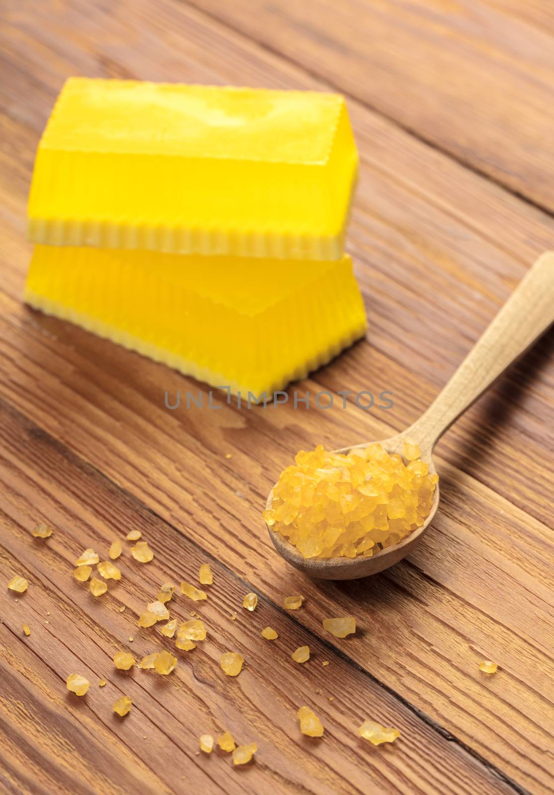 Yellow handmade soap and phyto salt on a wooden background