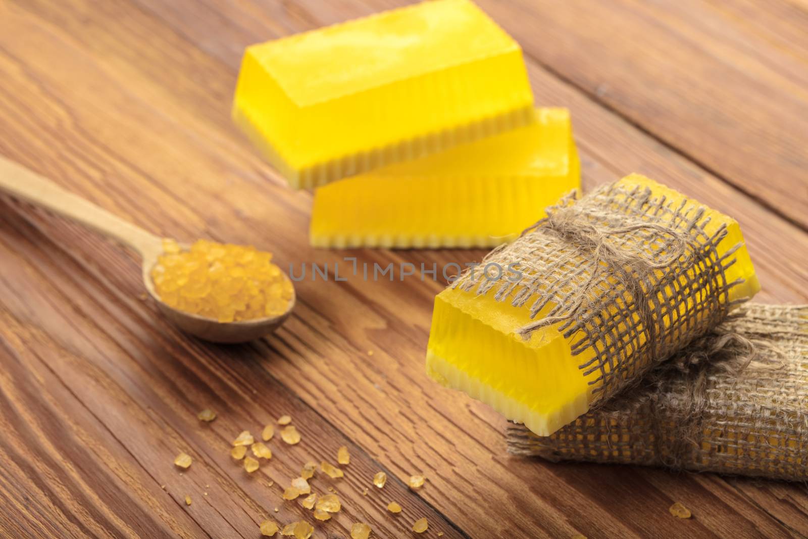 Yellow handmade soap and phyto salt on a wooden background