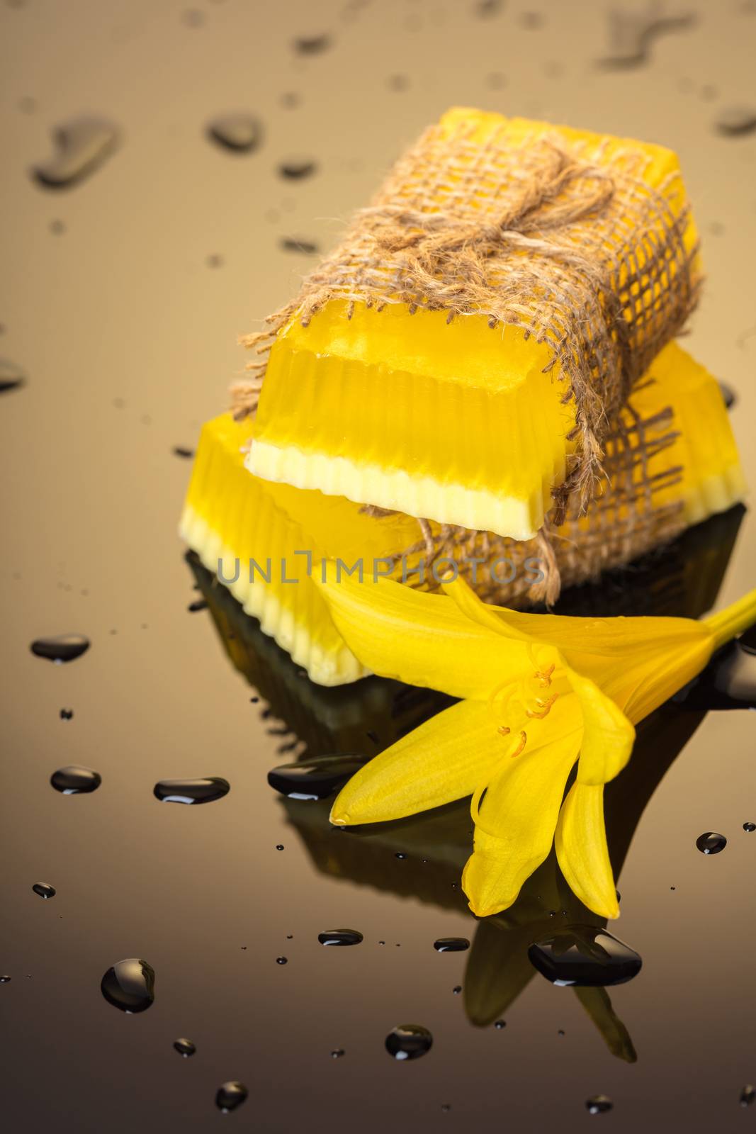 Handmade soap yellow on a dark background with drops of water