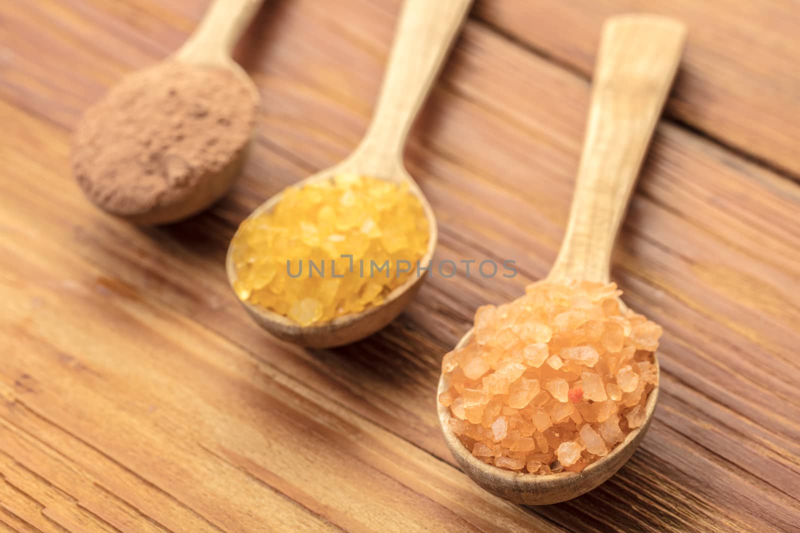 Spoons with phyto salt and clay on a wooden background