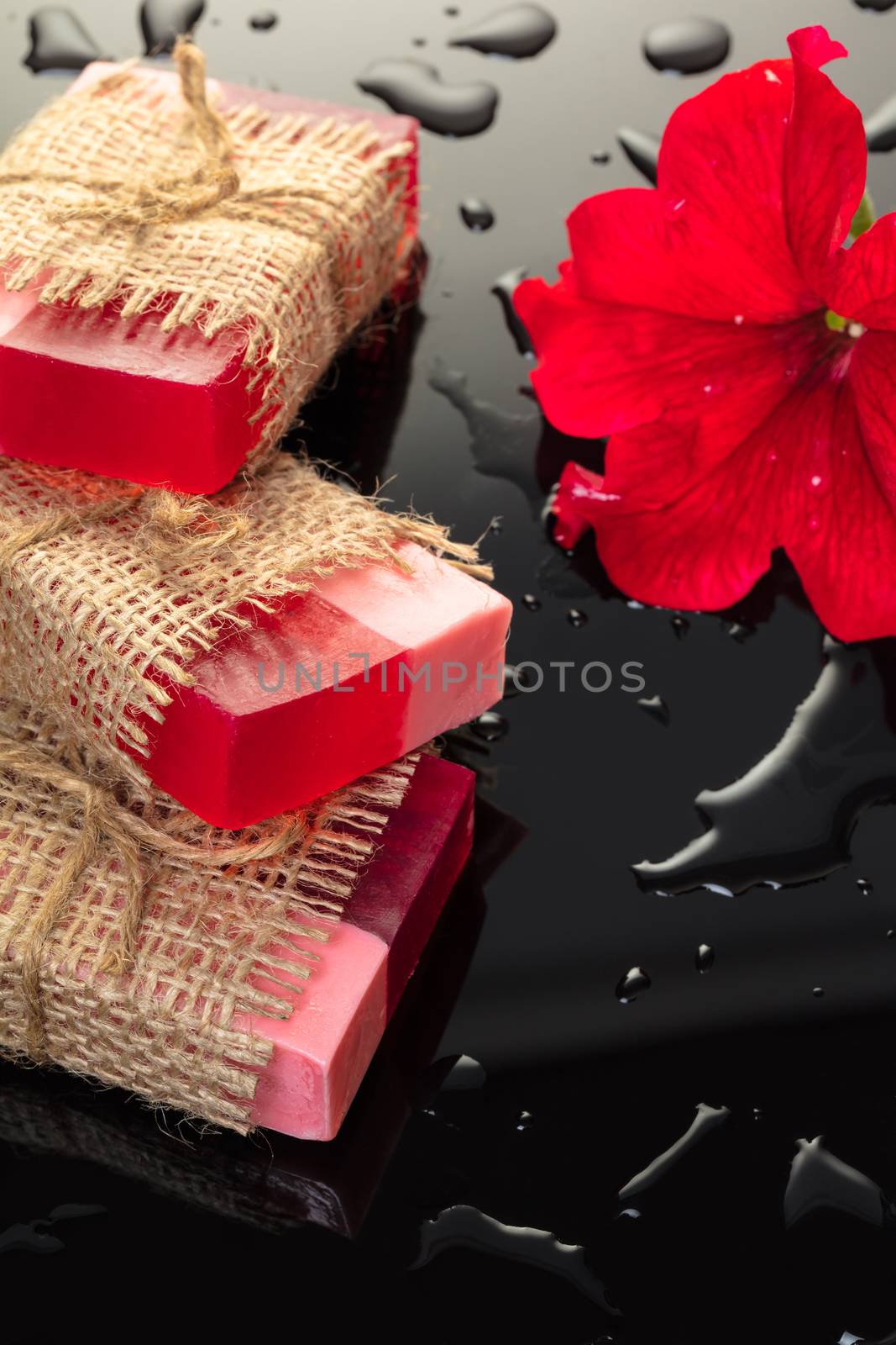 Handmade soap red with a flower petunia on black background