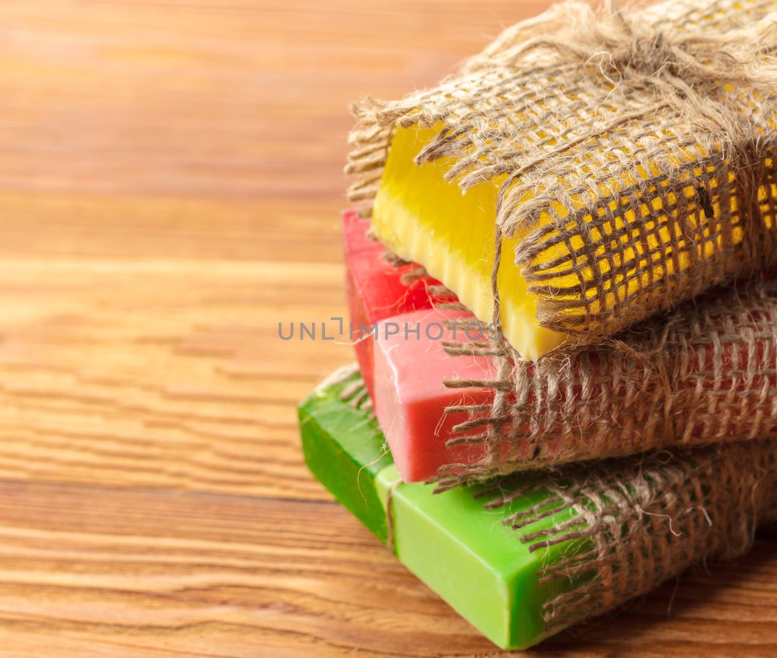 Colored handmade soap in a vintage packaging on wooden background