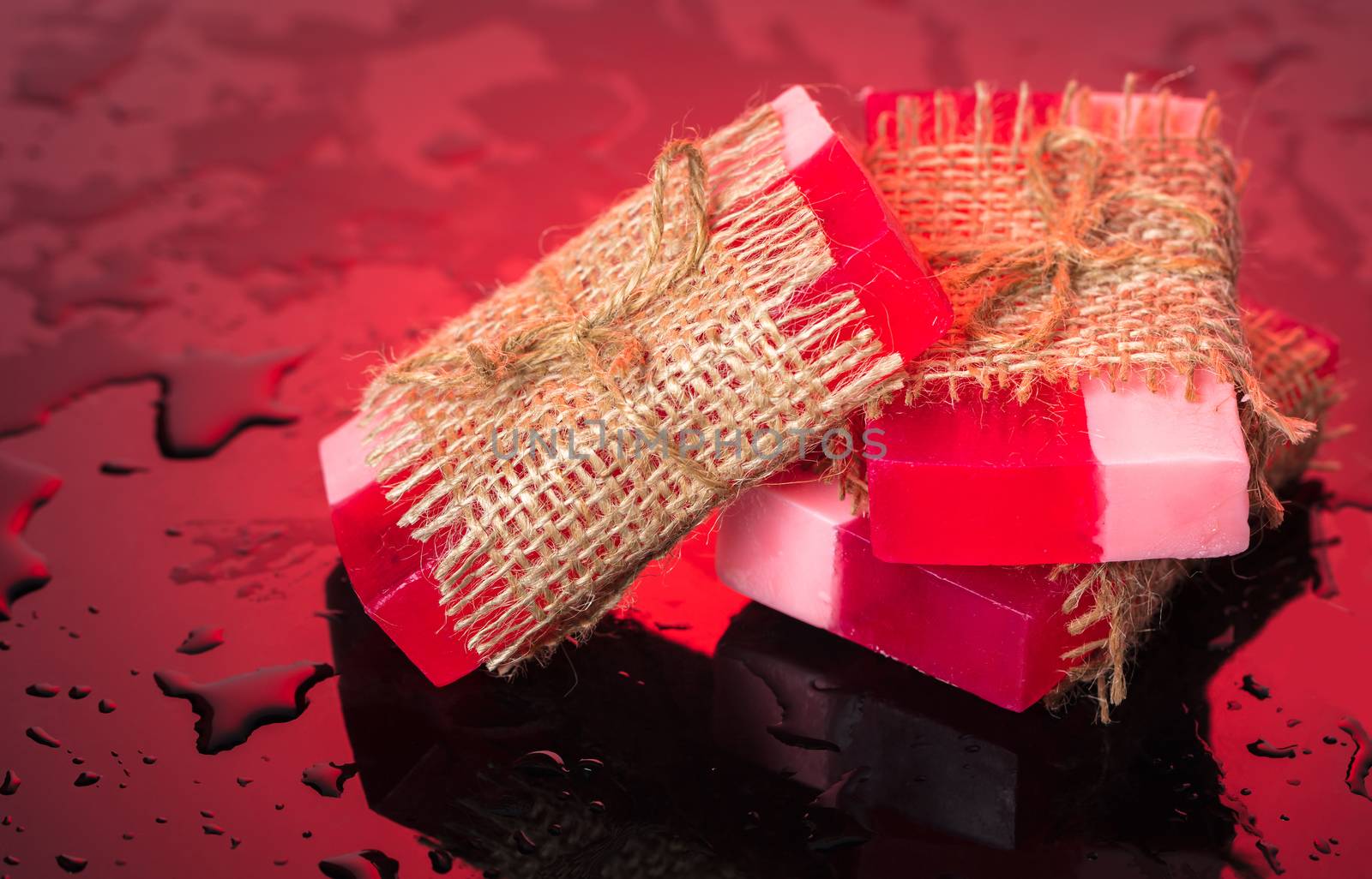 Handmade soap on red background and drops of water