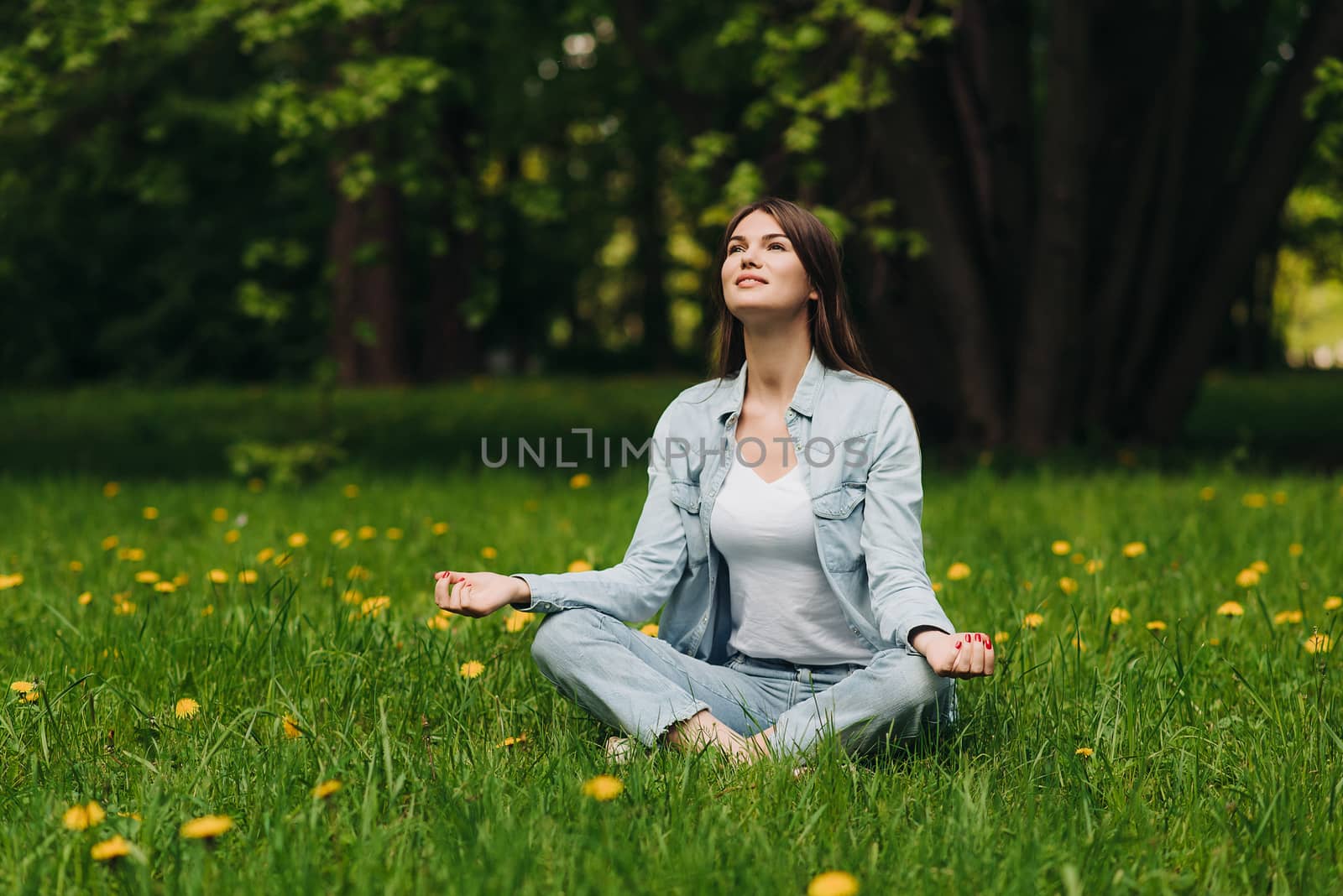 Young girl meditating in park by ALotOfPeople