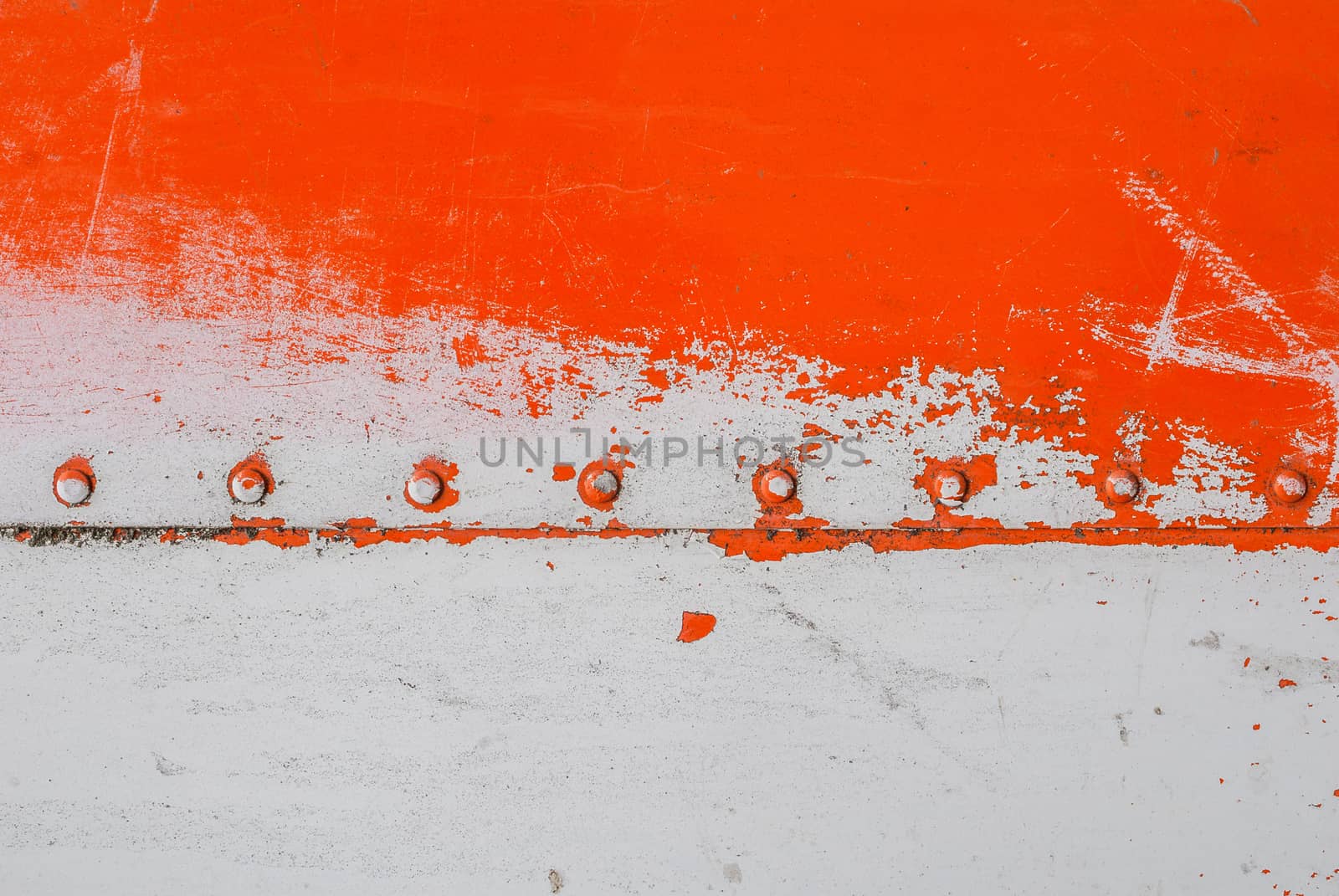 fragment of an iron surface is covered with orange and grey color paint, which has long been under the influence of different climatic conditions