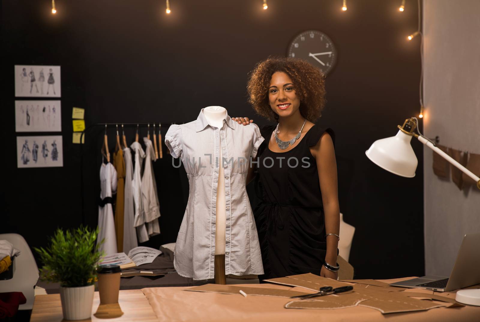 Portrait of a young fashion designer working on her atelier