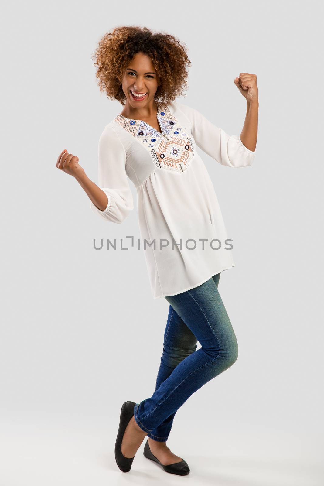 Beautiful and happy African American woman with arms raiaed