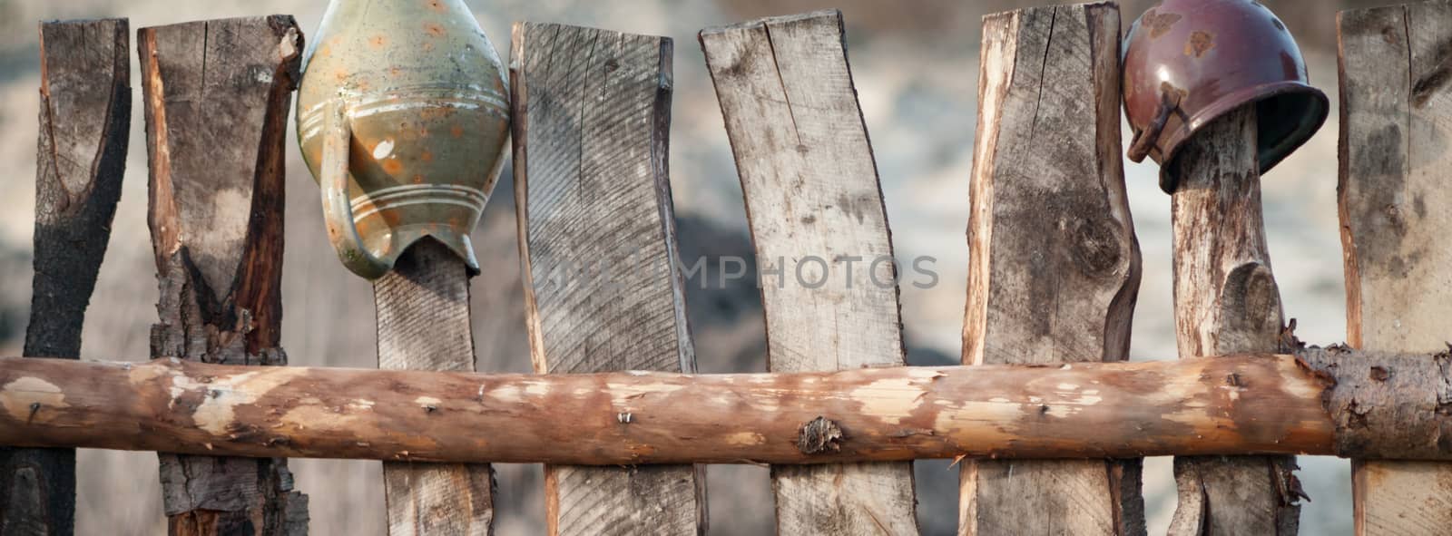 Old wooden boundary fence with nails on sunny day