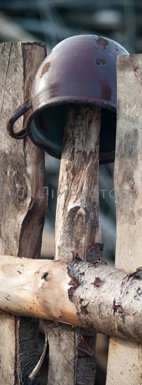 Old wooden boundary fence with nails on sunny day