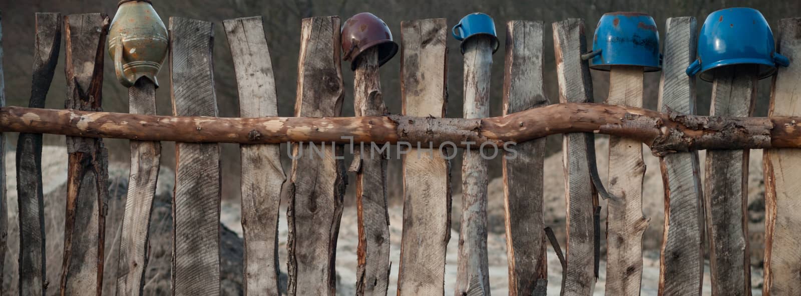Old wooden boundary fence with nails on sunny day