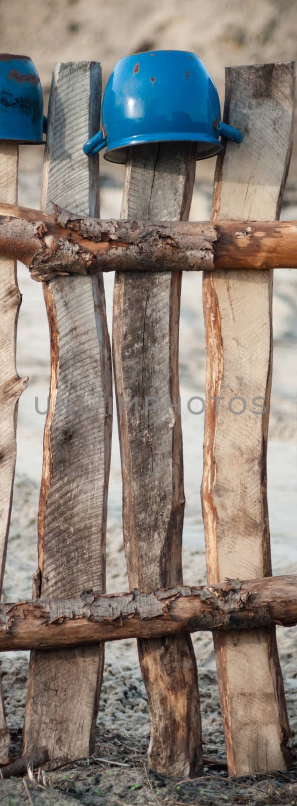 Old wooden boundary fence with nails on sunny day