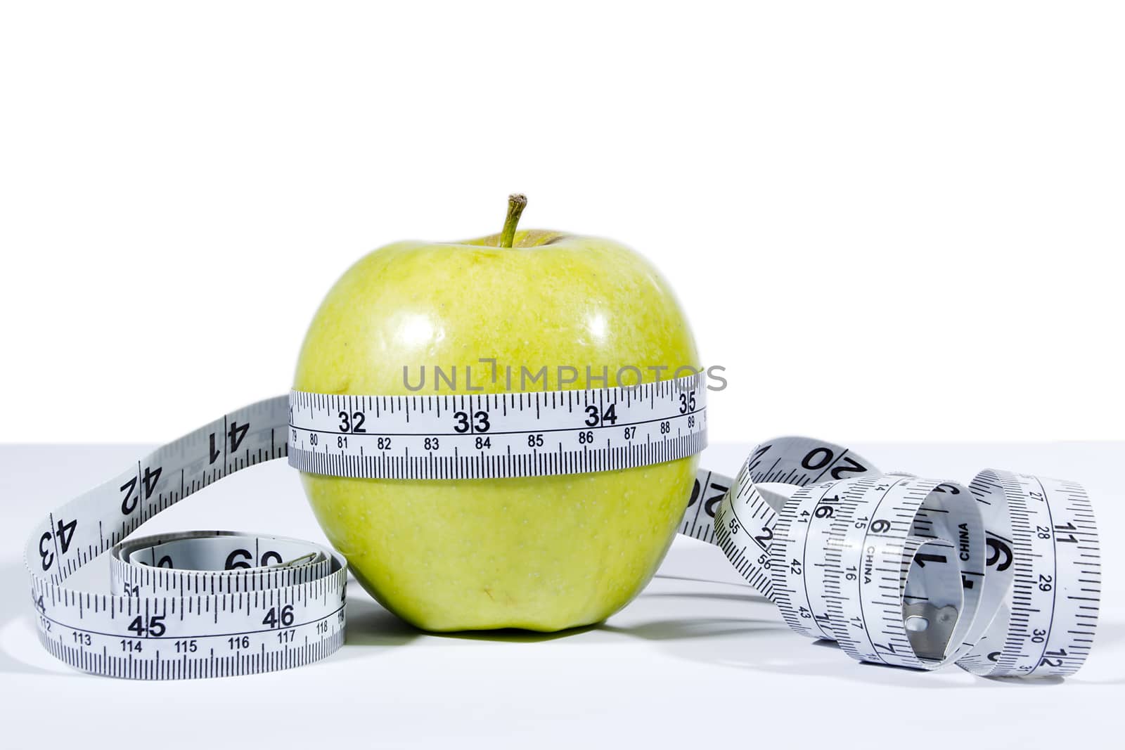 Green apple and measurement tape isolated on the white background