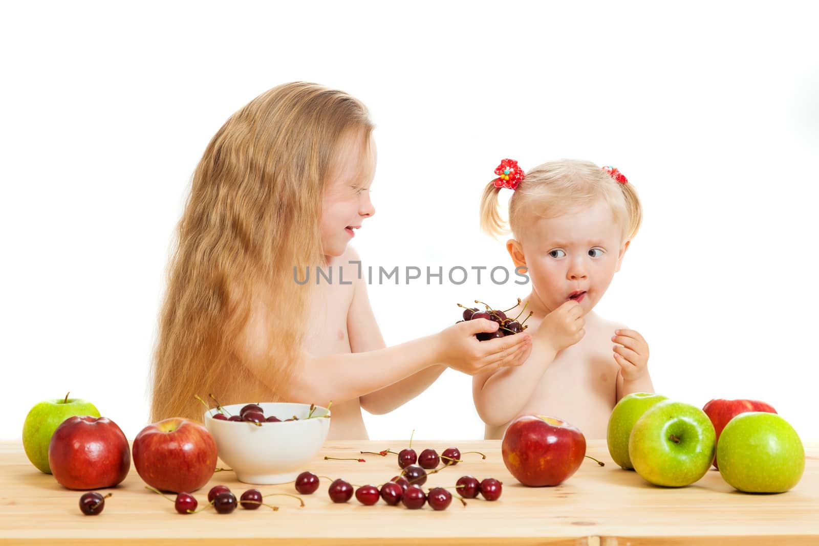 two little girls eat fruit by sveter