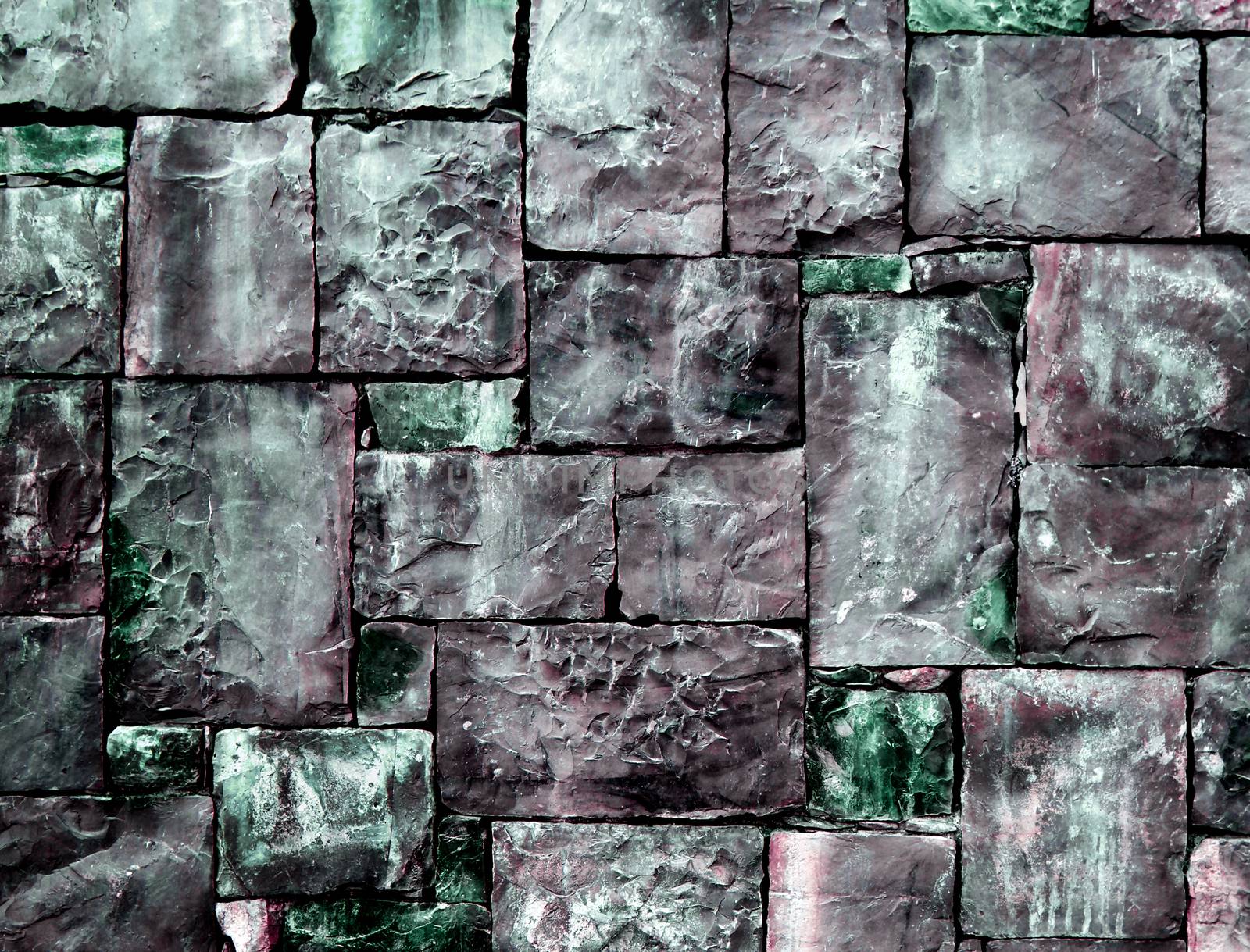 Background of Multi-Colored Cobblestones with Sharp Spears closeup Outdoors. Green and Gray Toned