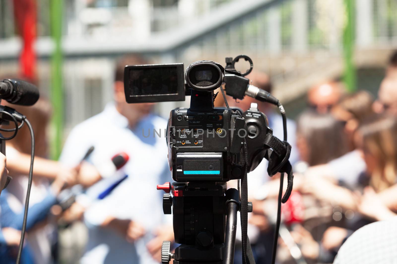 Covering an press event with a video camera. Media interview.