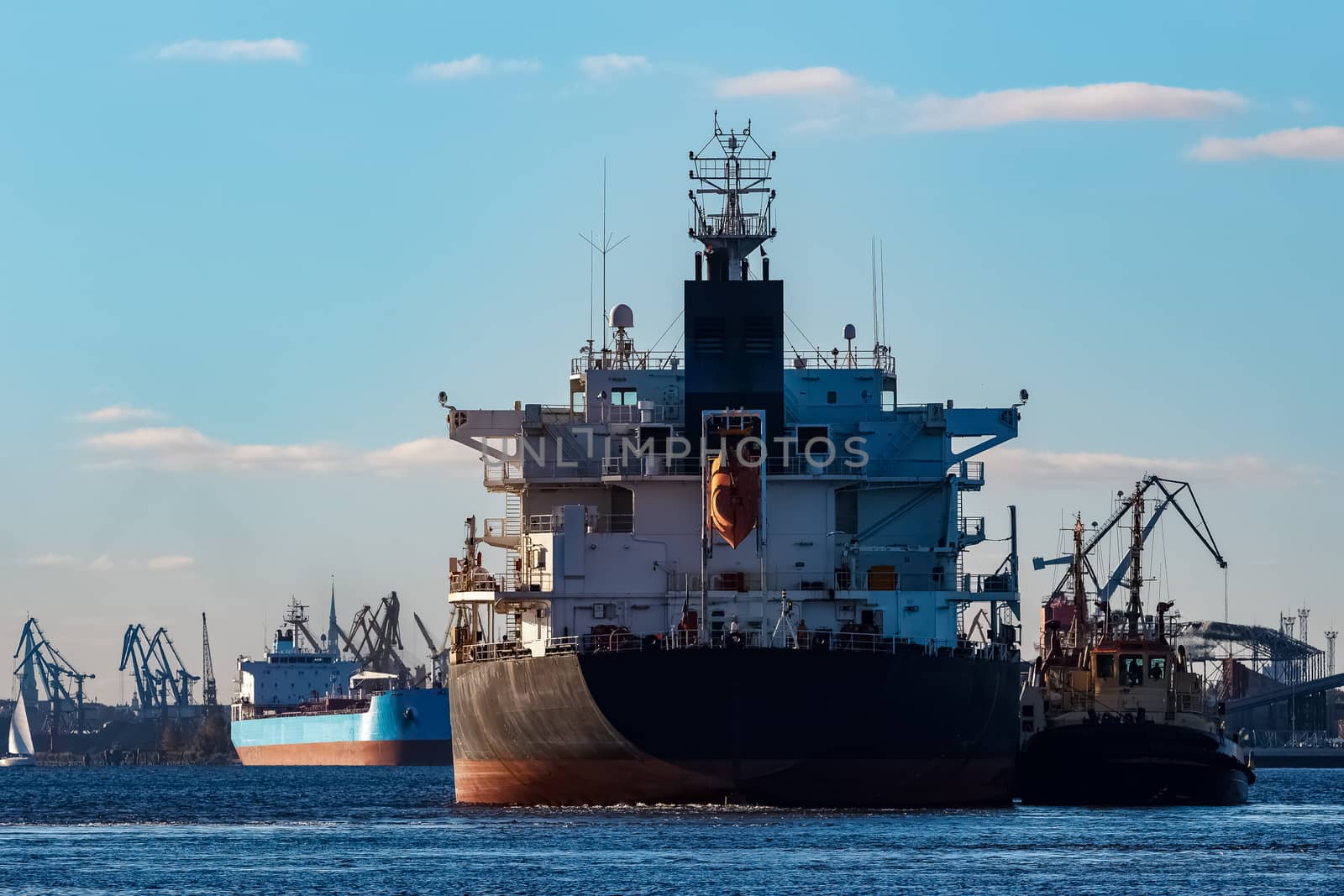 Black cargo ship entering the port of Riga, Europe