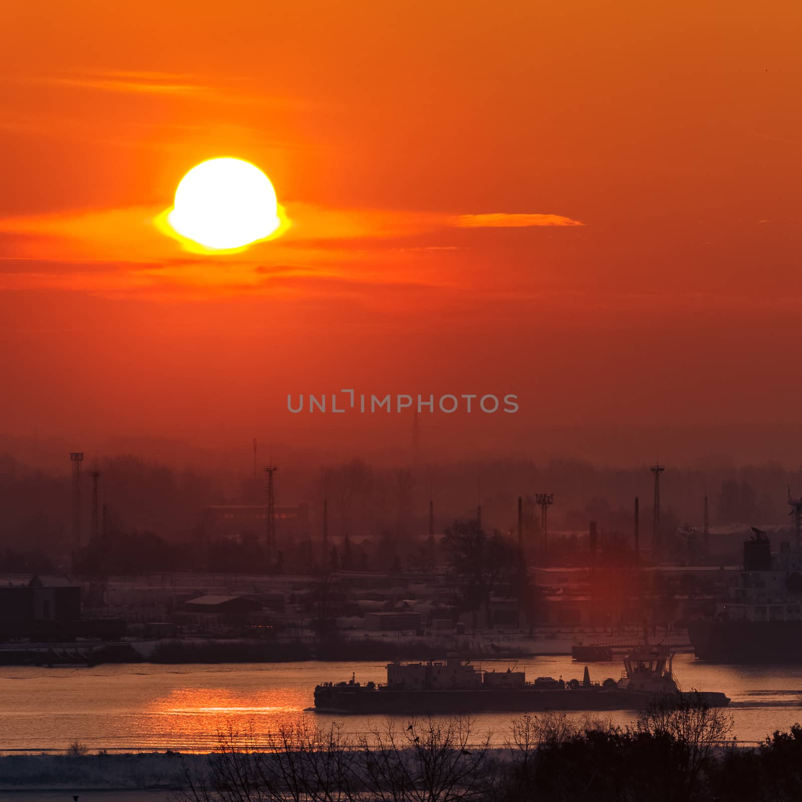 Hot orange sunset over the river. Urban landscape