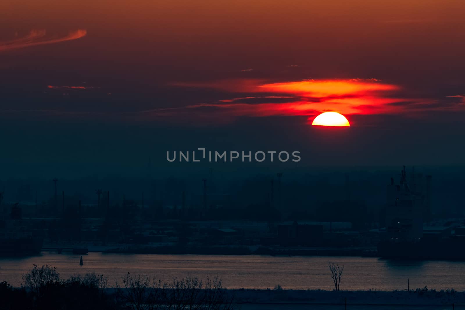 Hot orange sunset over the river. Urban landscape