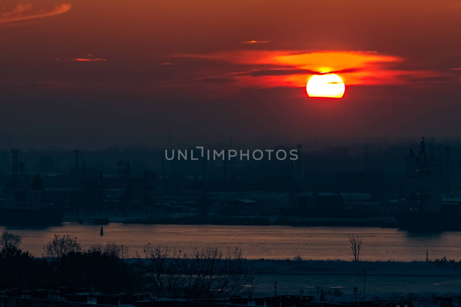 Hot orange sunset over the river. Urban landscape