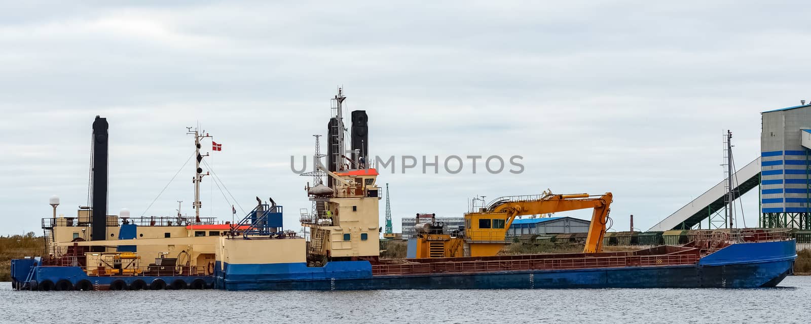 Blue cargo ship loading in the port of Riga, Europe