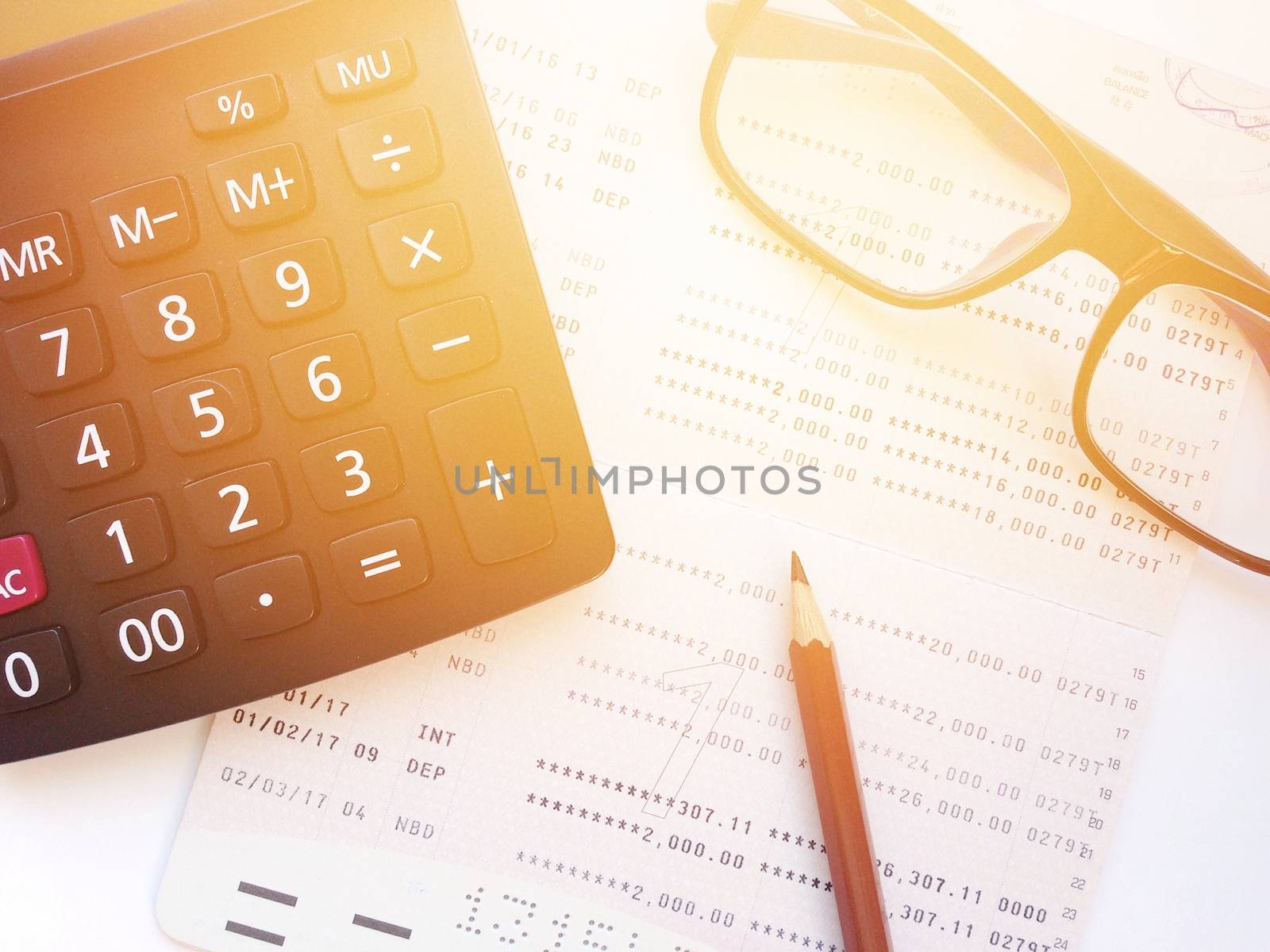 Business, finance, savings, banking or  loan concept : Pencil, eyeglasses, calculator  and savings account passbook or financial statement on white background