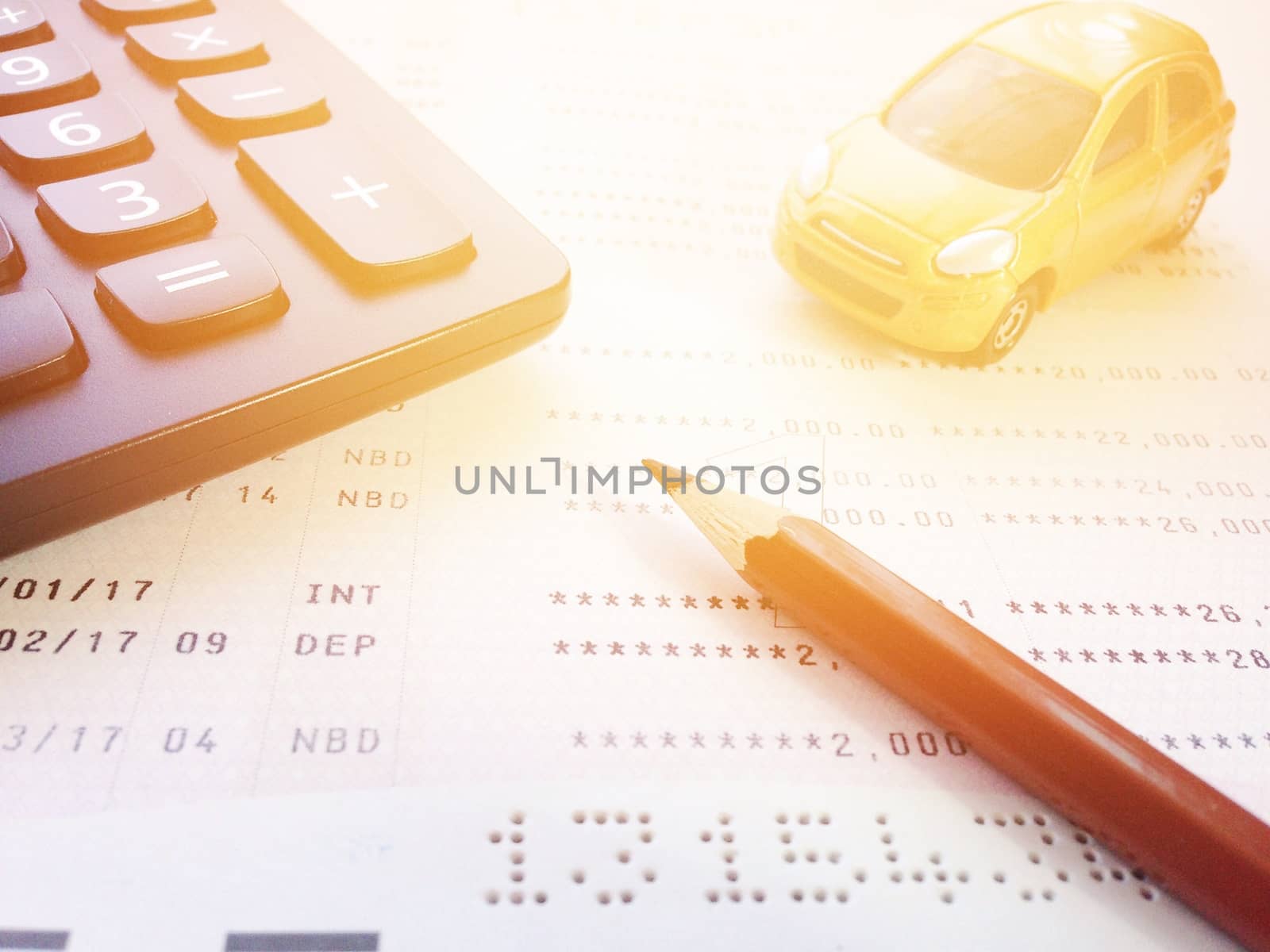 Business, finance, savings, banking or car loan concept : Miniature car model, pencil, calculator and savings account passbook or financial statement on white background