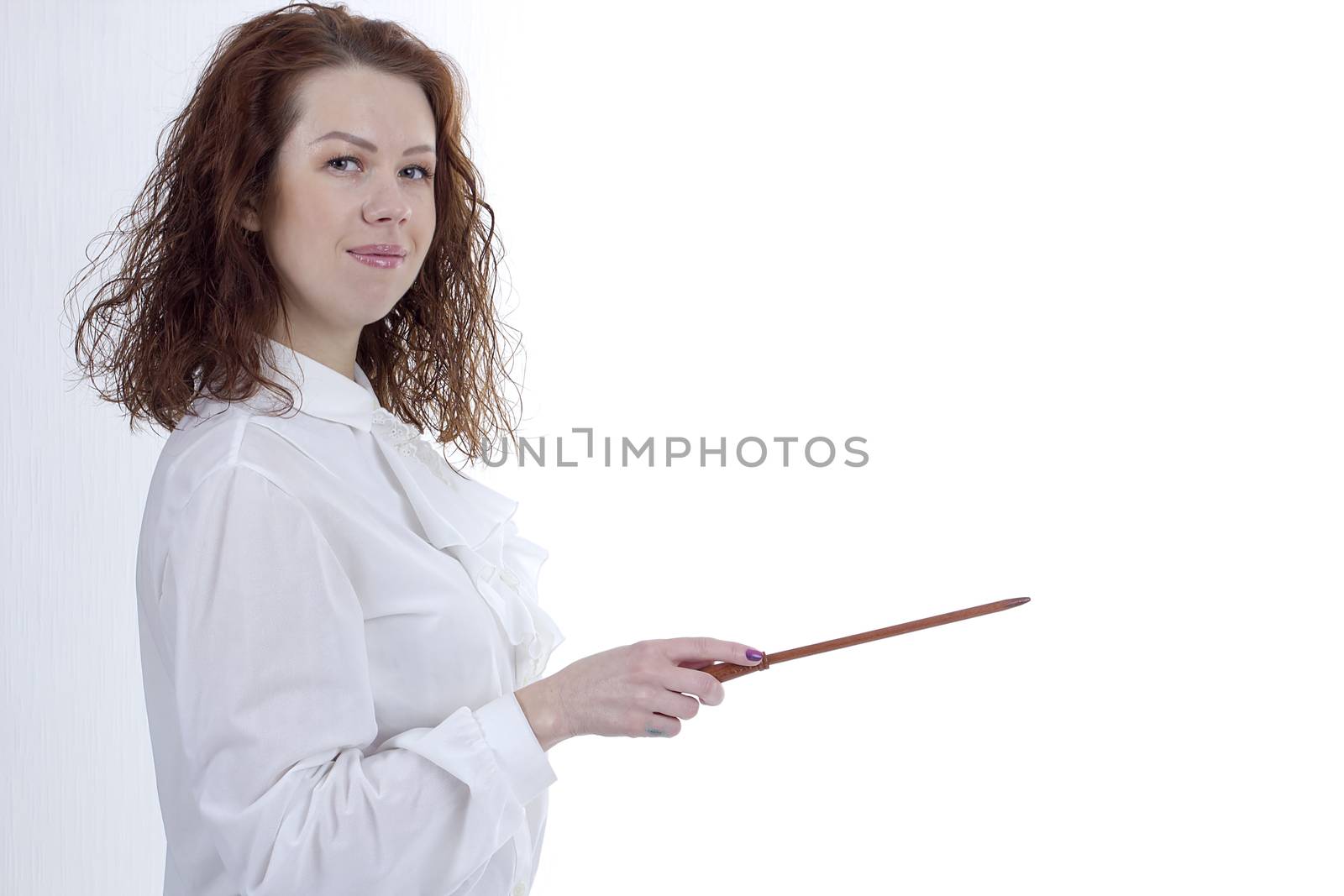 Young woman is pointing out something with a pointer on a blackboard