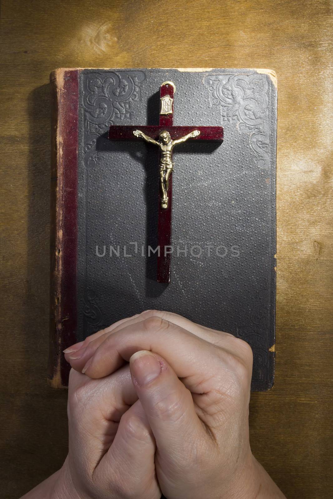 Hands with a crucifix and an old book by VIPDesignUSA