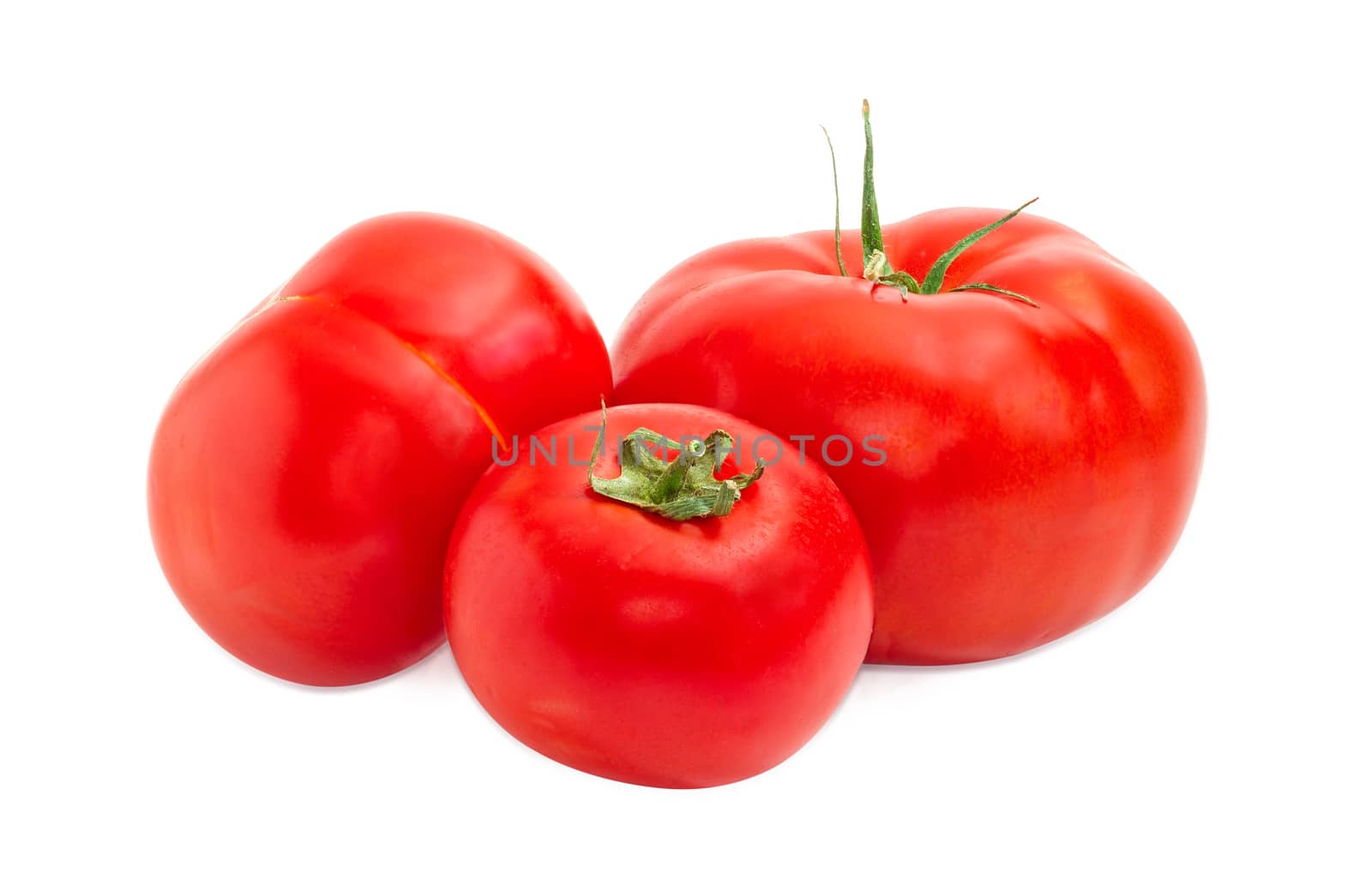 Three ripe red tomatoes different sizes closeup on a light background
