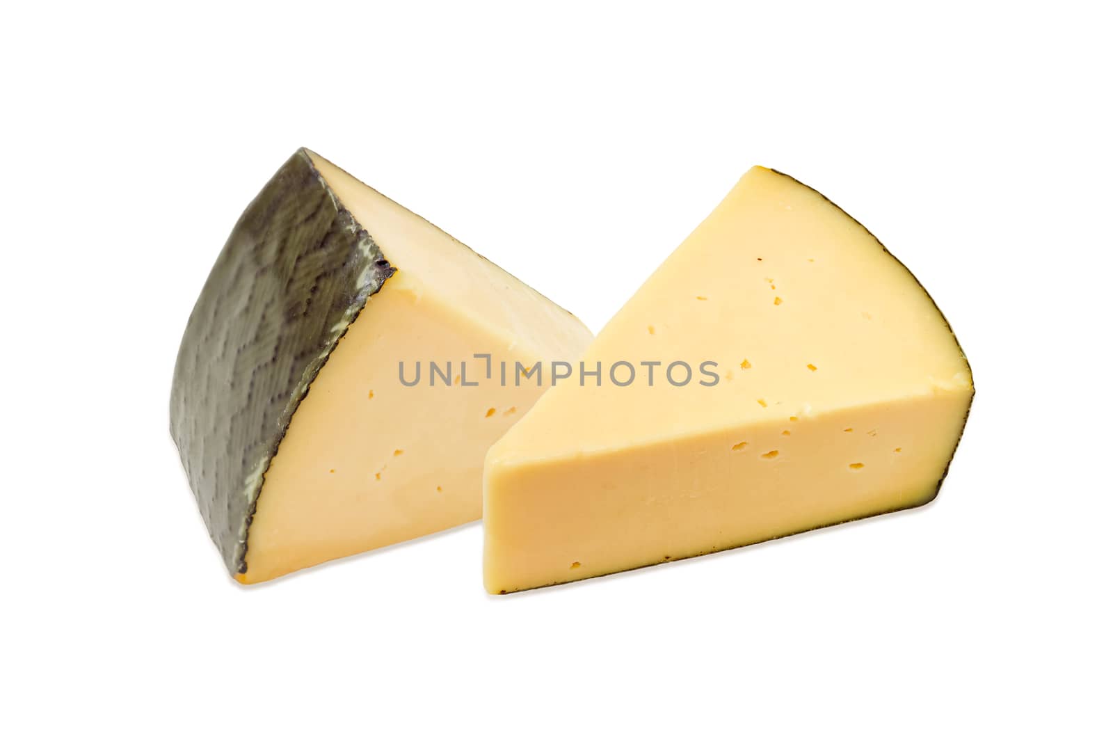 Two pieces of the hard cheese on a light background
