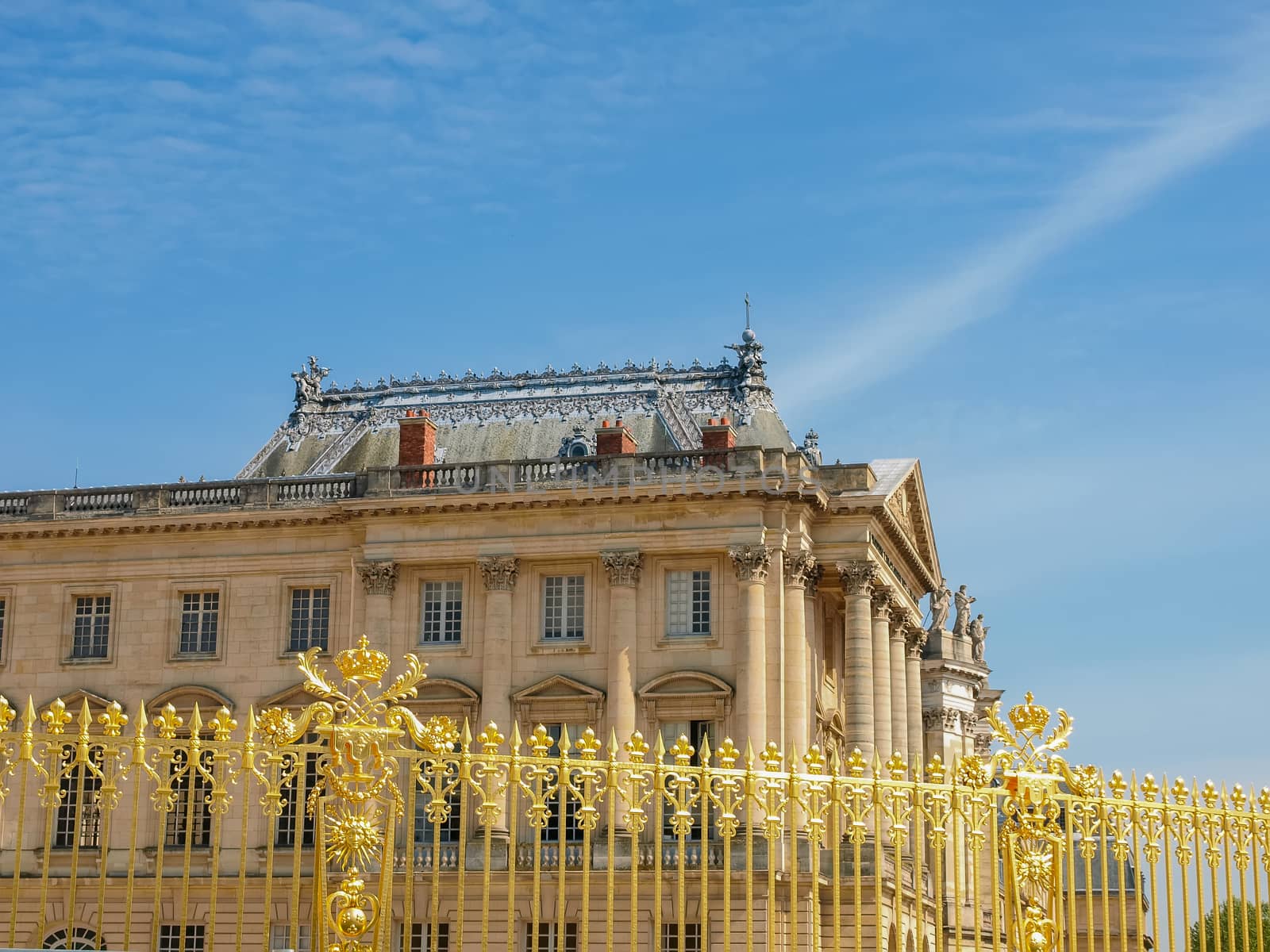 View of the part of a north wing of the Palace of Versailles across his gilding fence on the background of the sky, France
