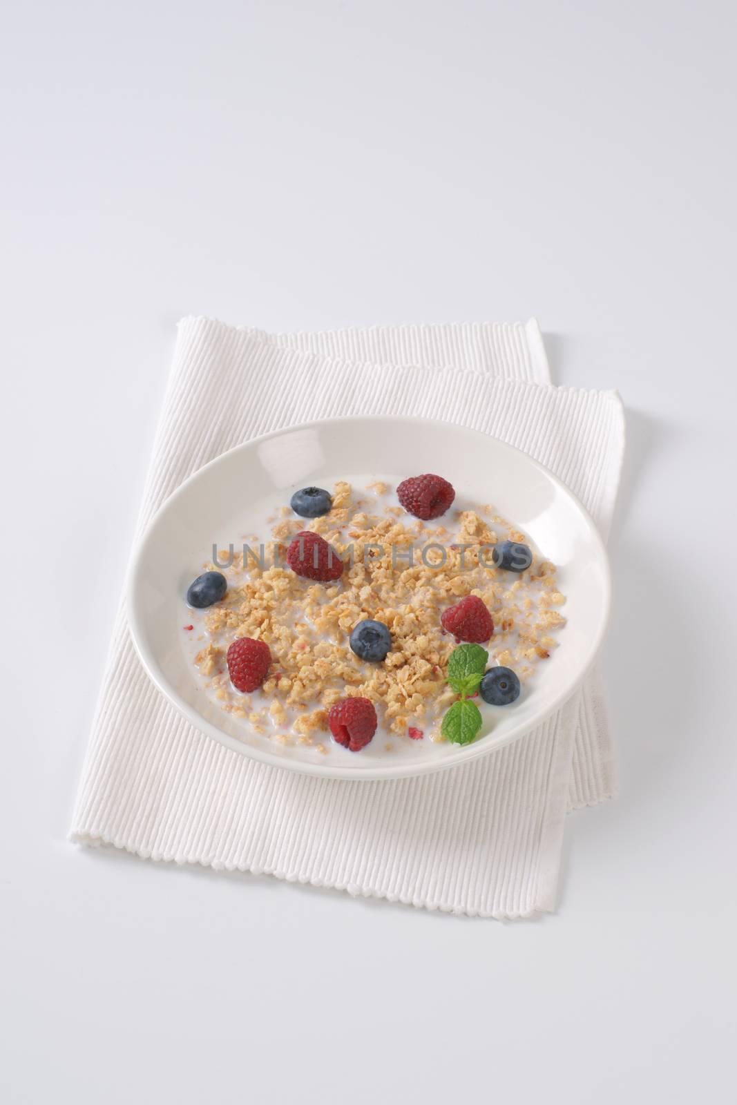 plate of granola with milk and fresh berry fruit