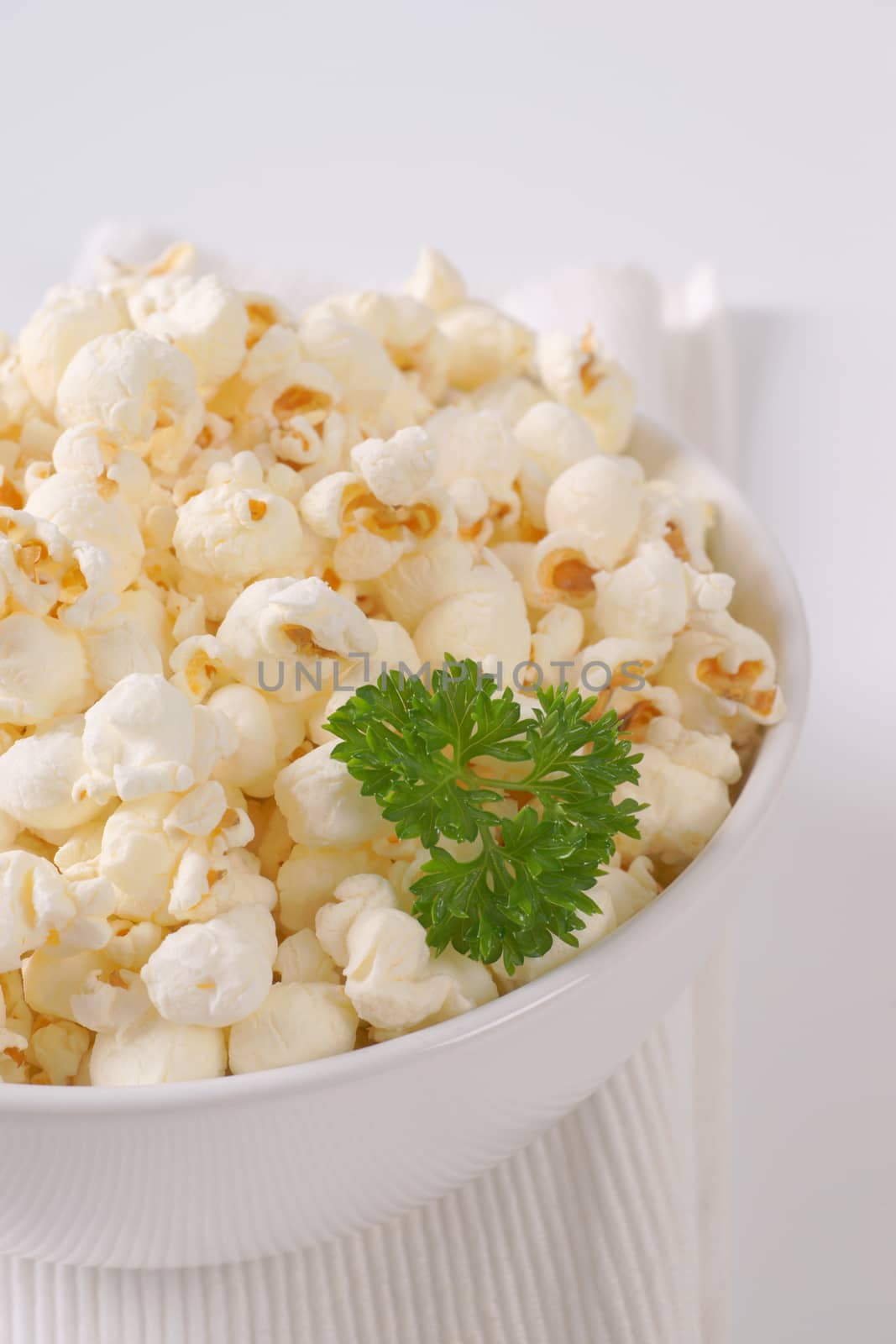 bowl of fresh popcorn on white place mat