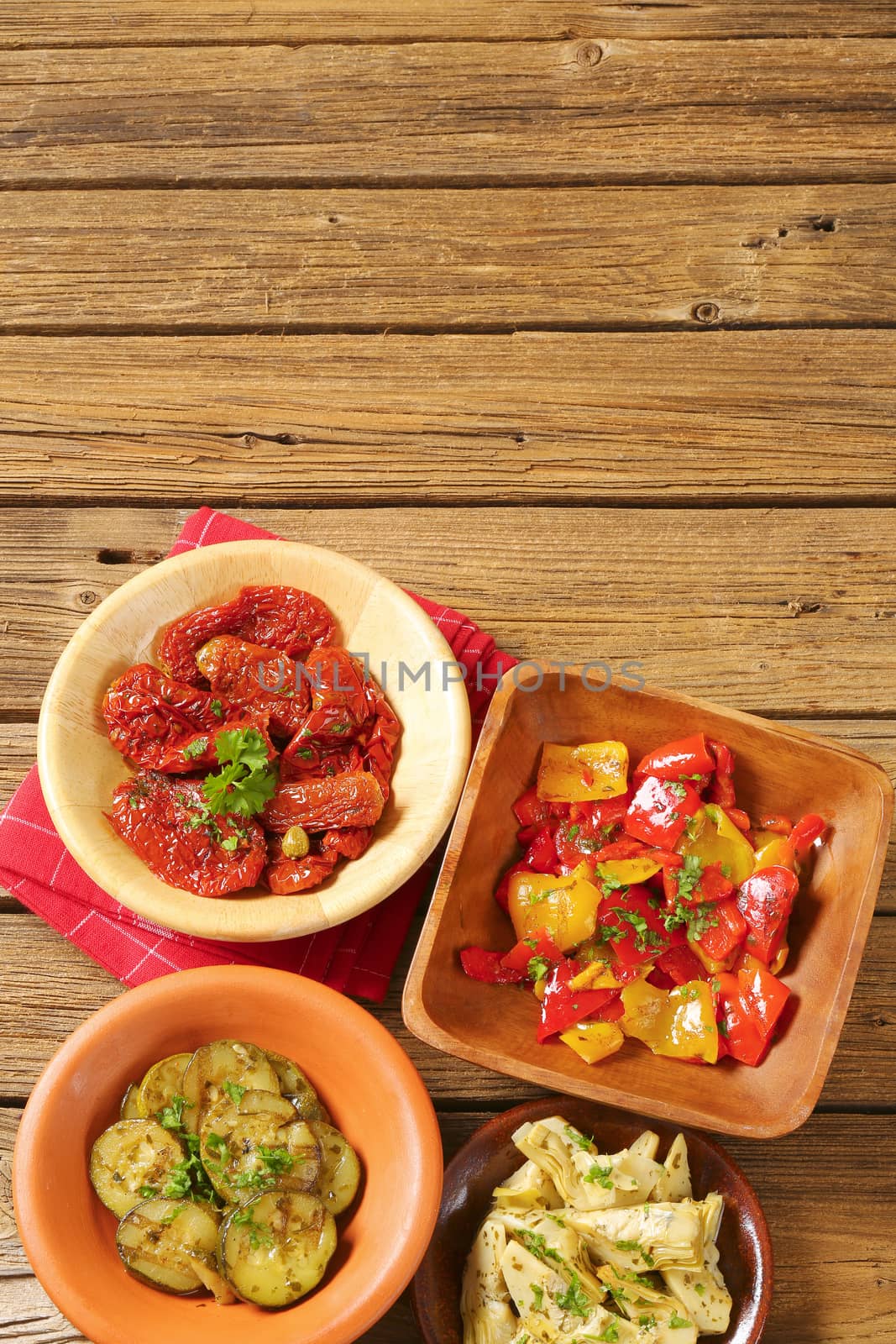 bowls of assorted pickled vegetables on wooden background