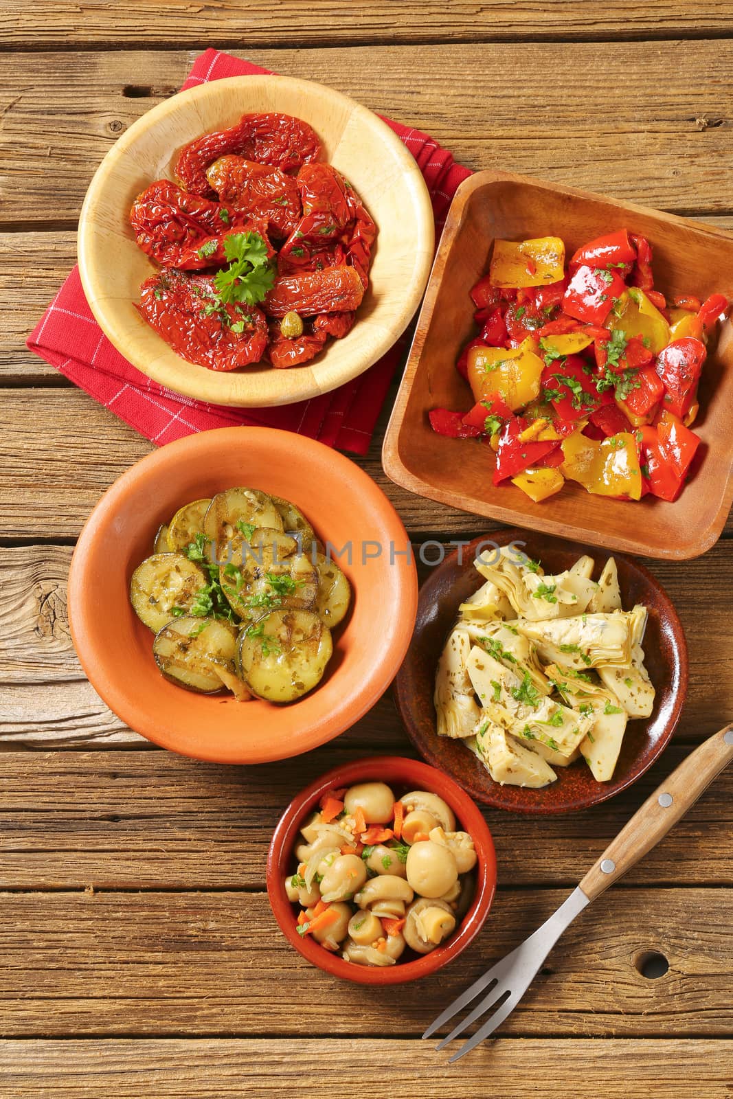 bowls of assorted pickled vegetables on wooden background