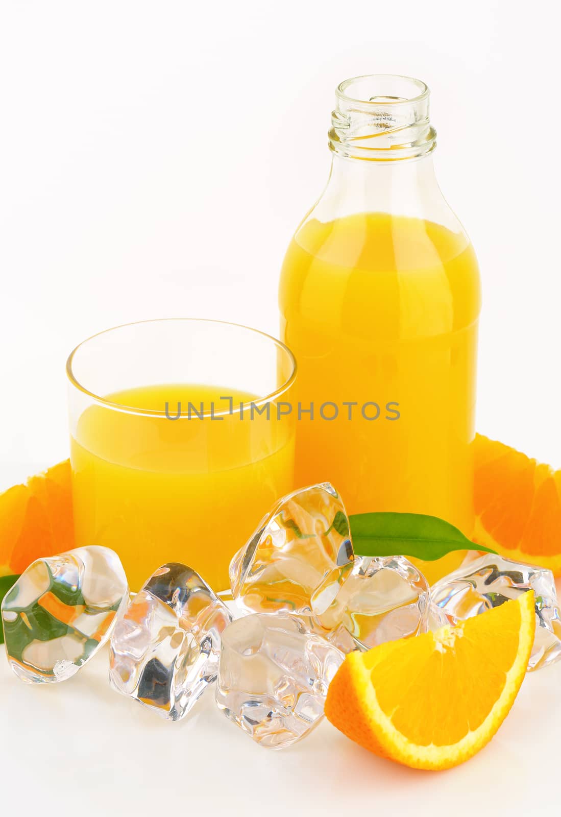 glass and bottle of fresh orange juice on white background