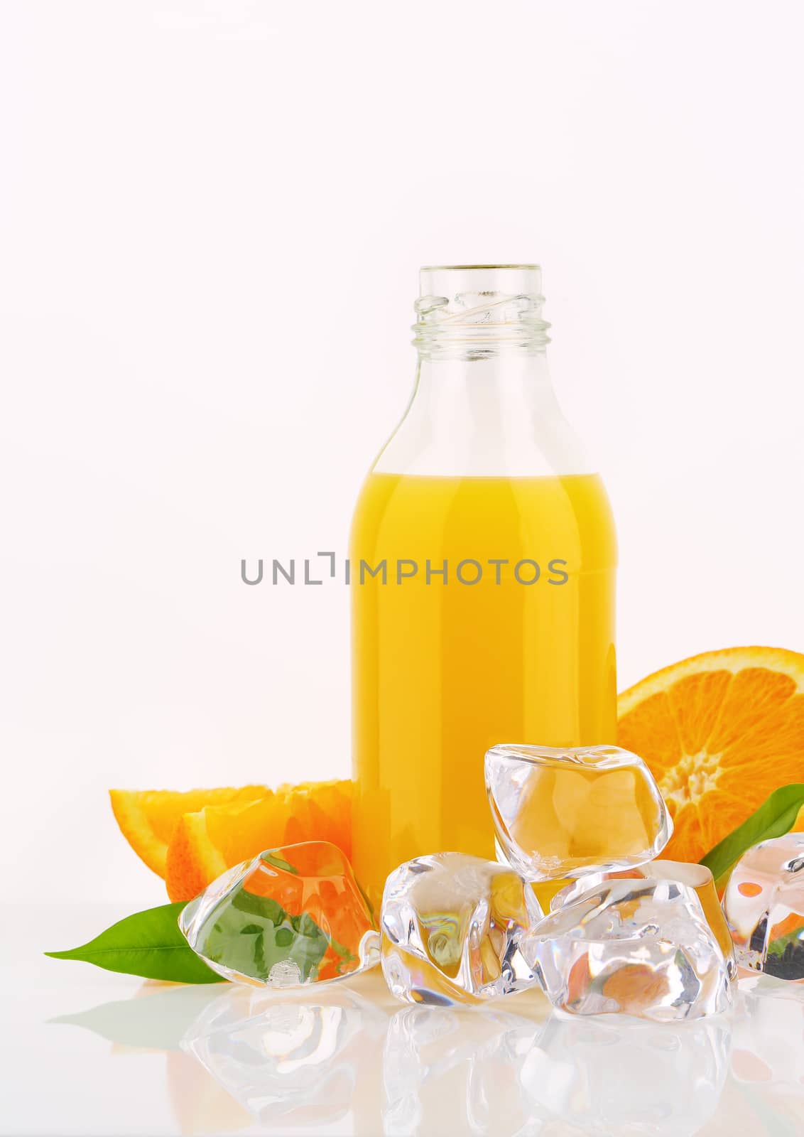 bottle of orange juice and ice cubes on white background